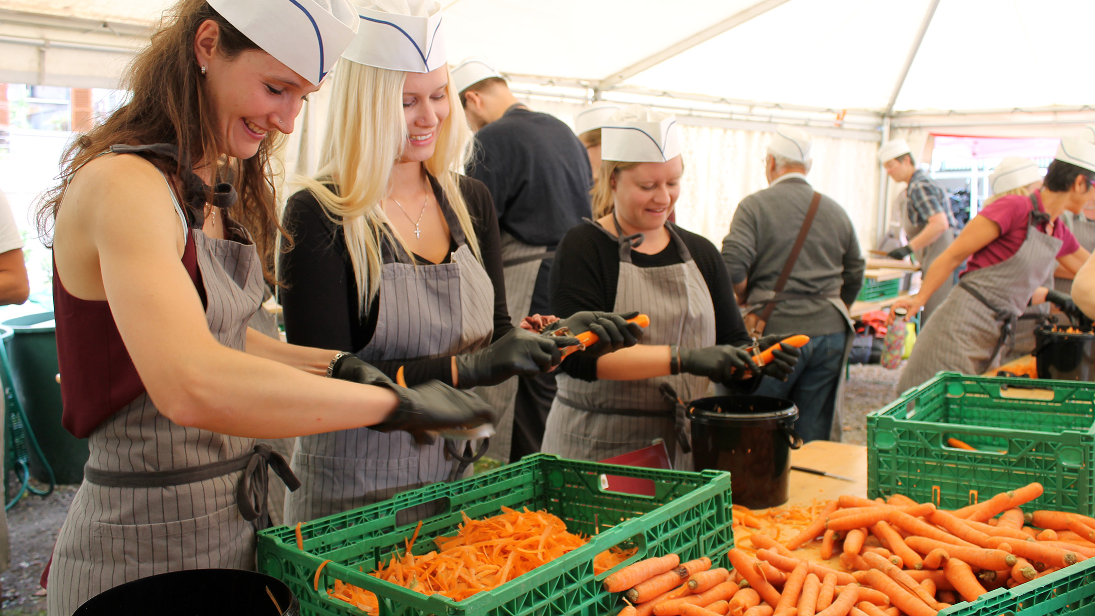 Tre donne puliscono e preparano varie cassette di carote