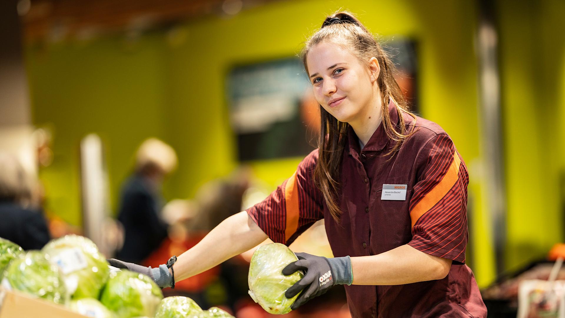 Une apprentie en tenue Migros
