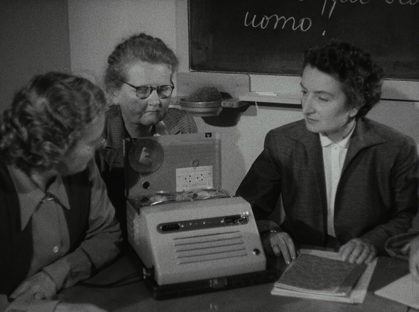 A black-and-white photograph of three women studying
