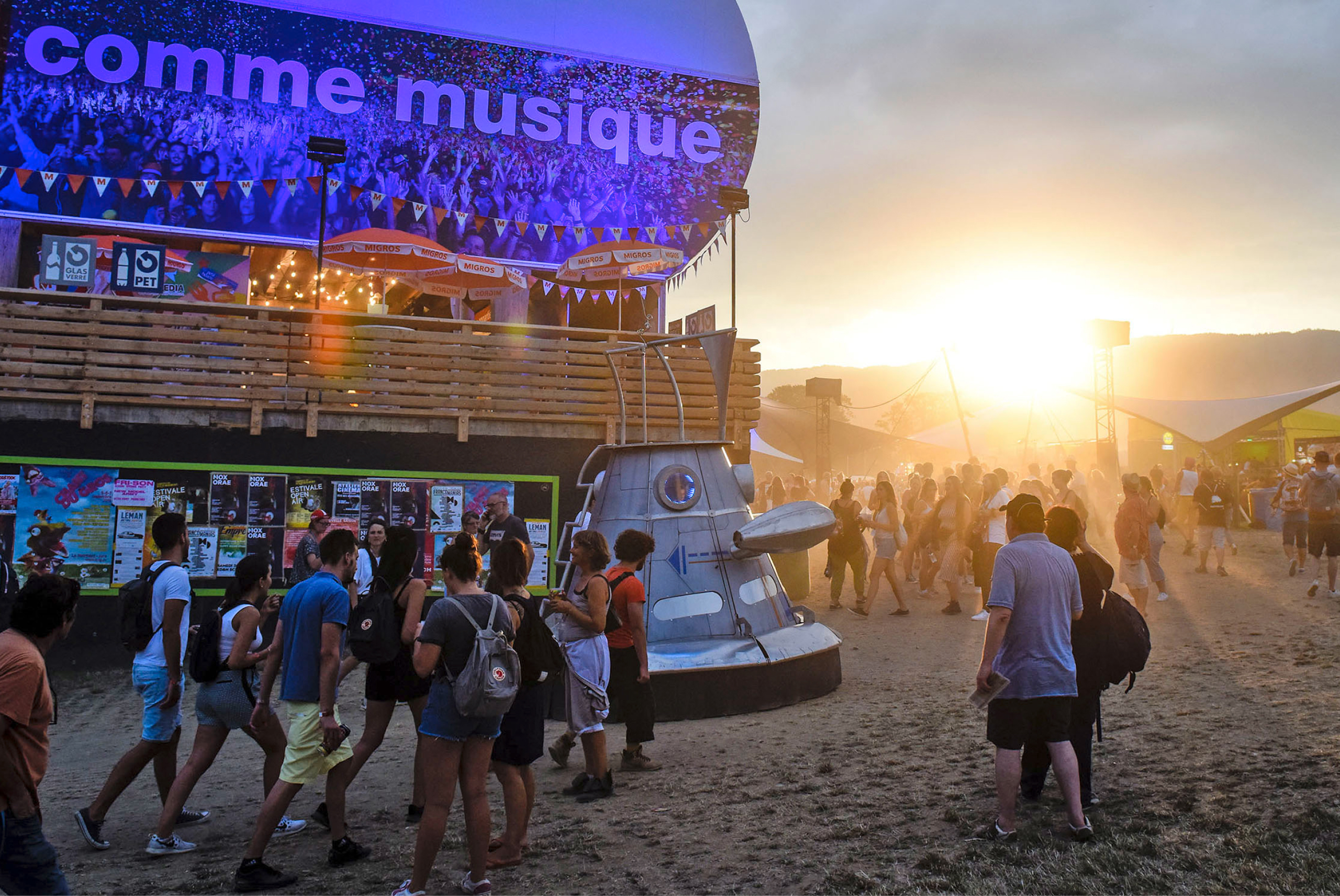 Des festivaliers et festivalières passent un moment agréable devant un coucher de soleil.