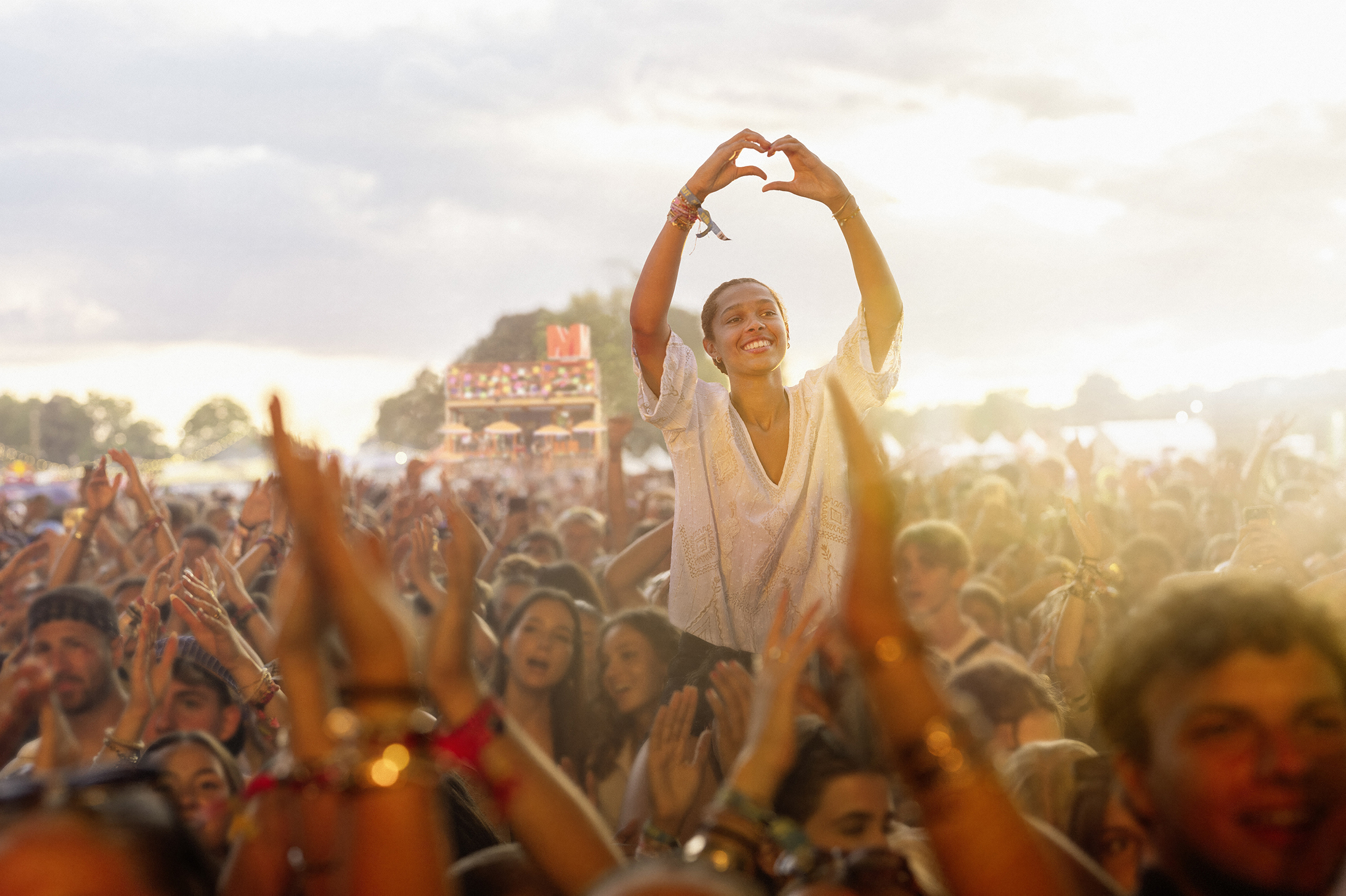 Eine Frau im Festivalpublikum formt mit den Händen ein Herz