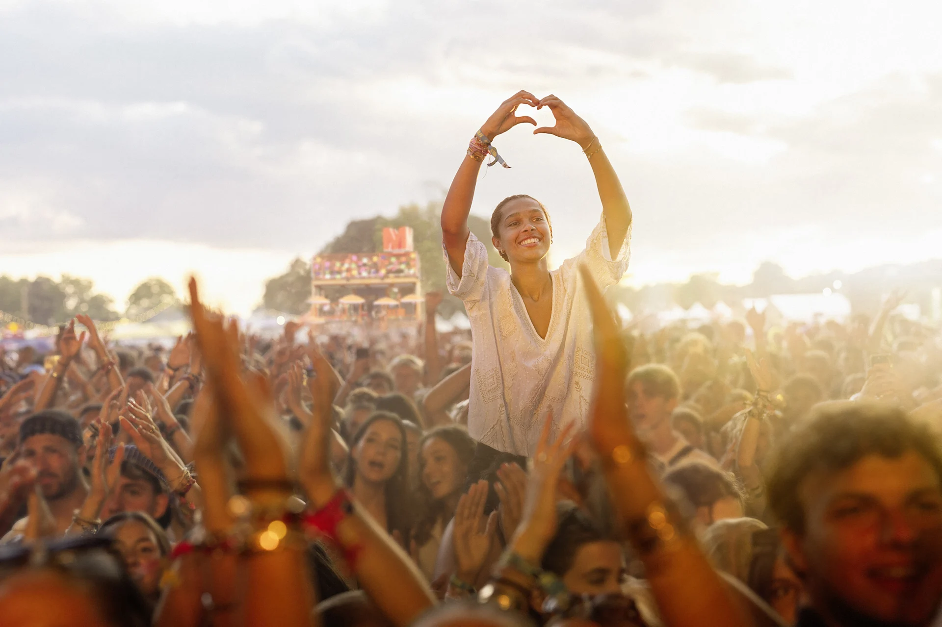 Une femme dans le public du festival forme un cœur avec ses mains