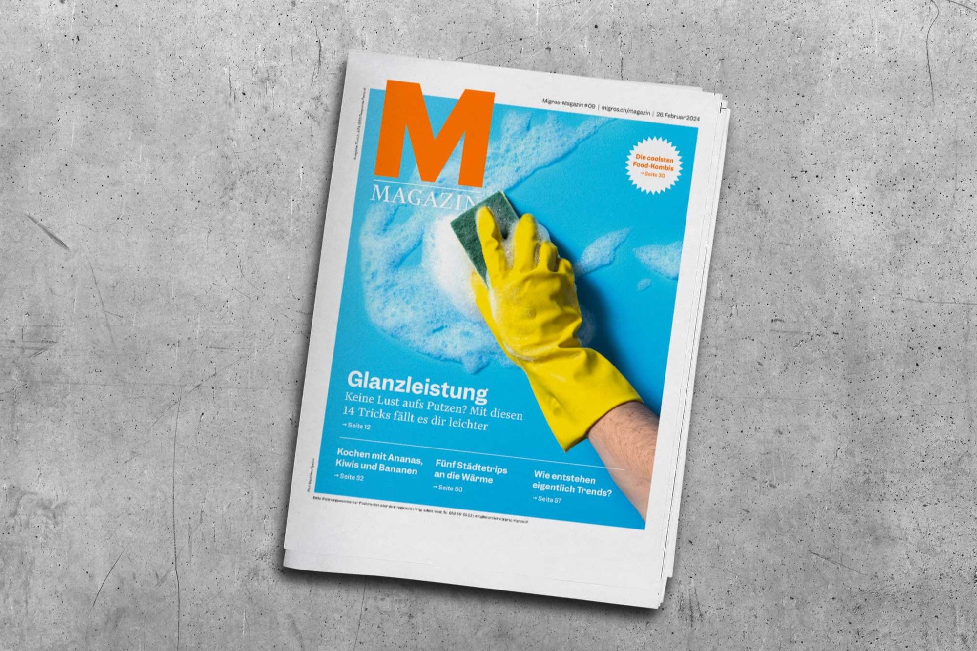 Un numero della rivista Migros su un tavolo grigio.