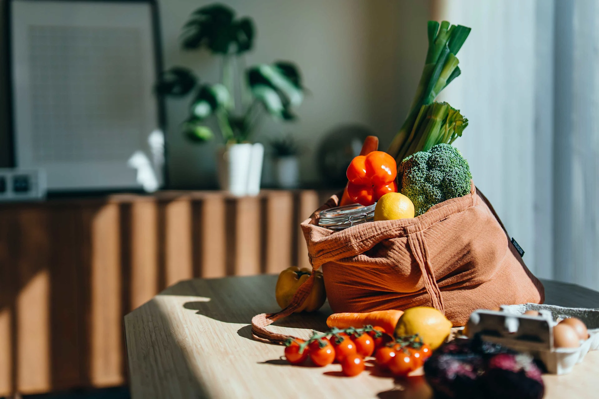 Borsa della spesa ecologica con verdure fresche e cibo multicolore sul tavolo della cucina