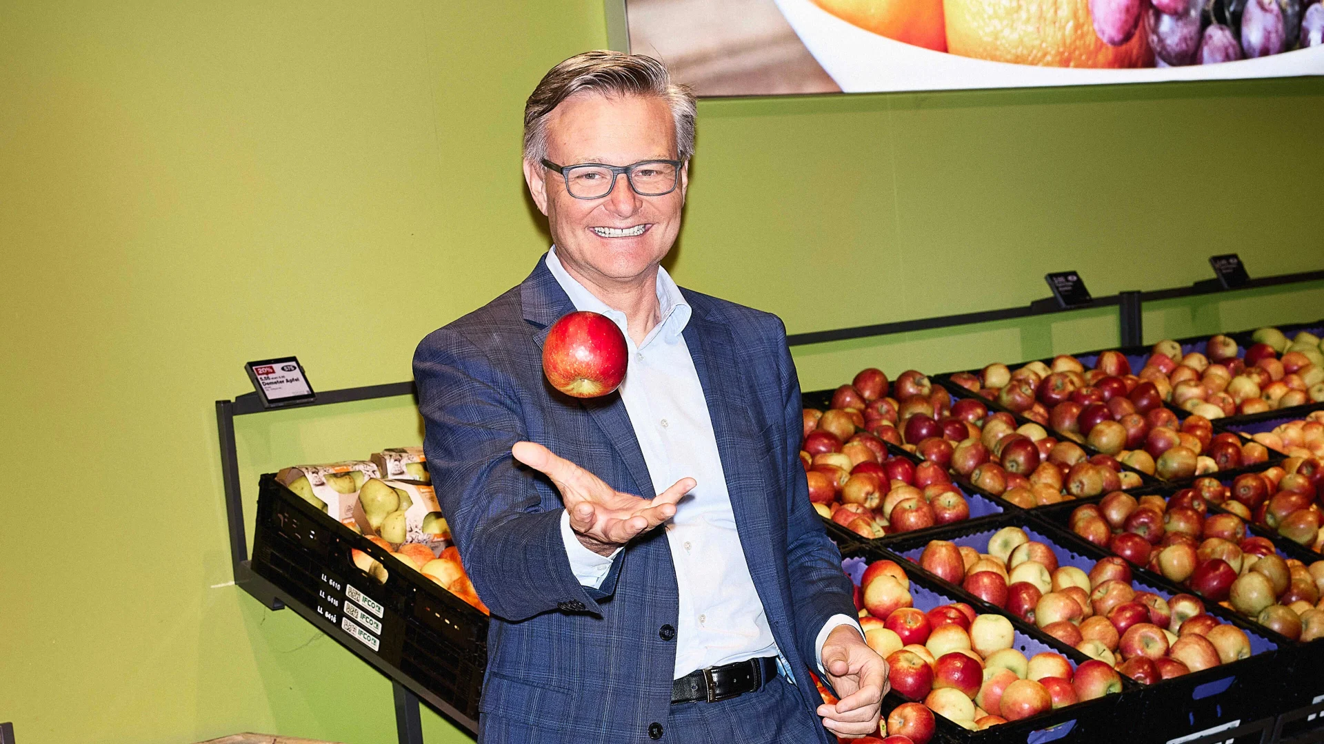 Mario Irminger au supermarché devant l'étalage de pommes