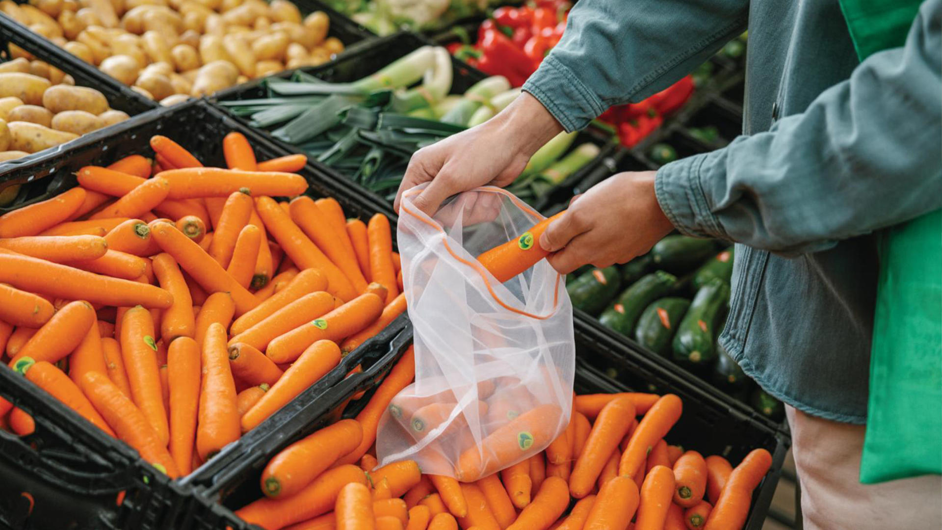 Un homme emballe des carottes dans un Veggie Bag