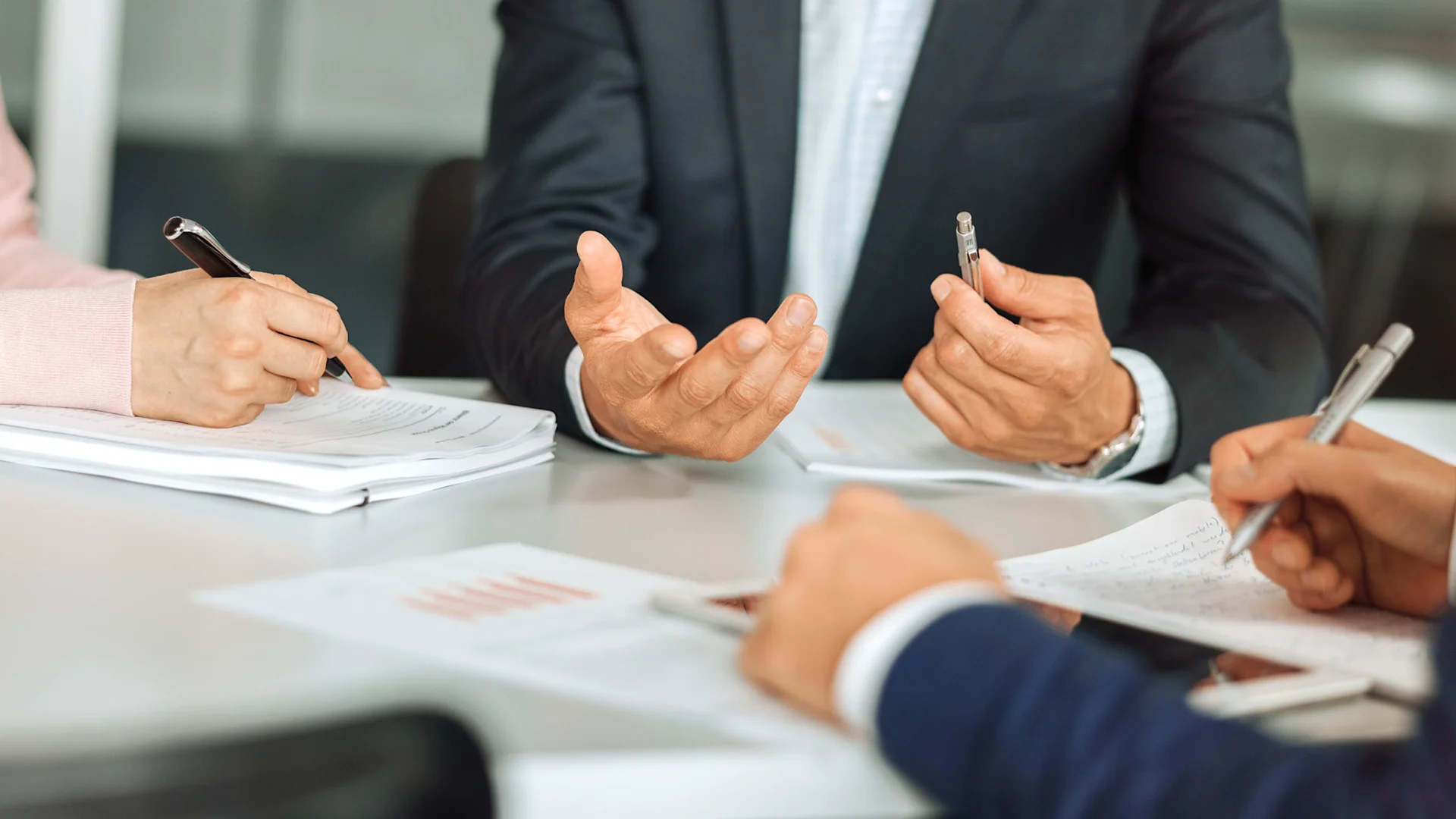 A close-up of gesticulating hands in a meeting.