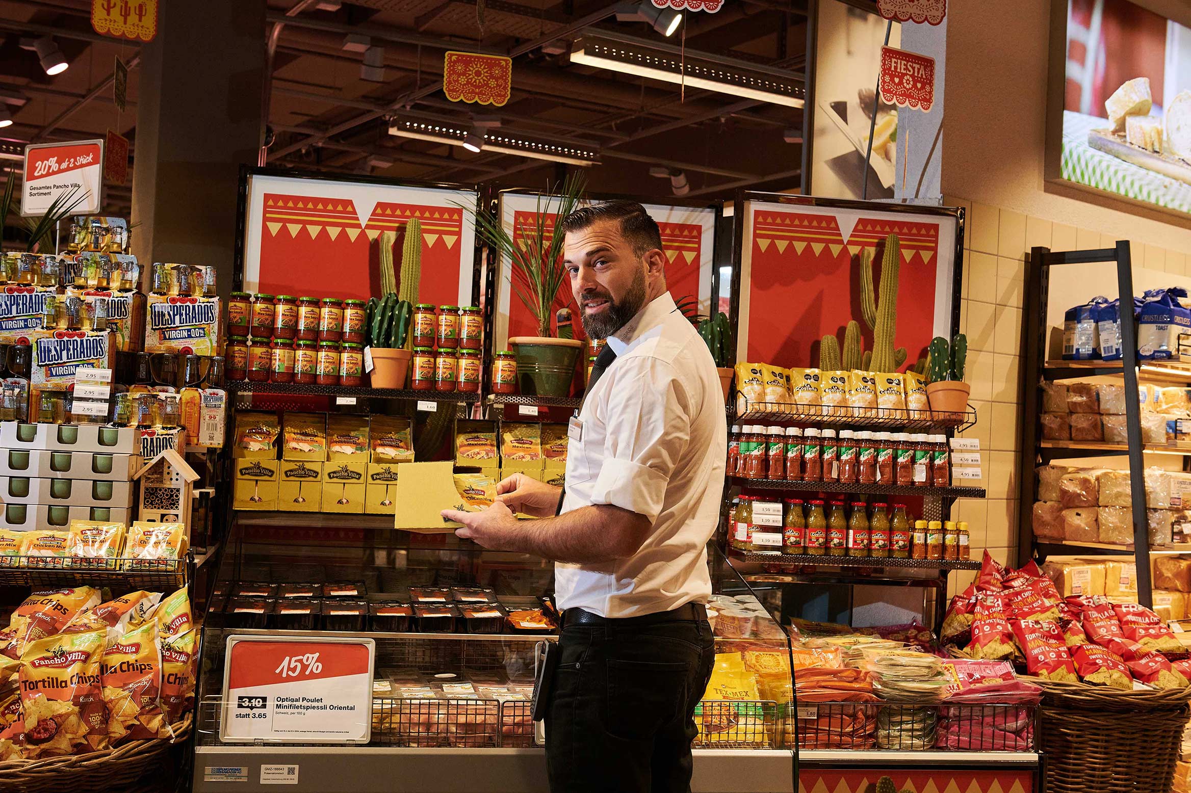 Filalleiter Yves Brunner arrangiert die Produkte zur besseren Präsentation.