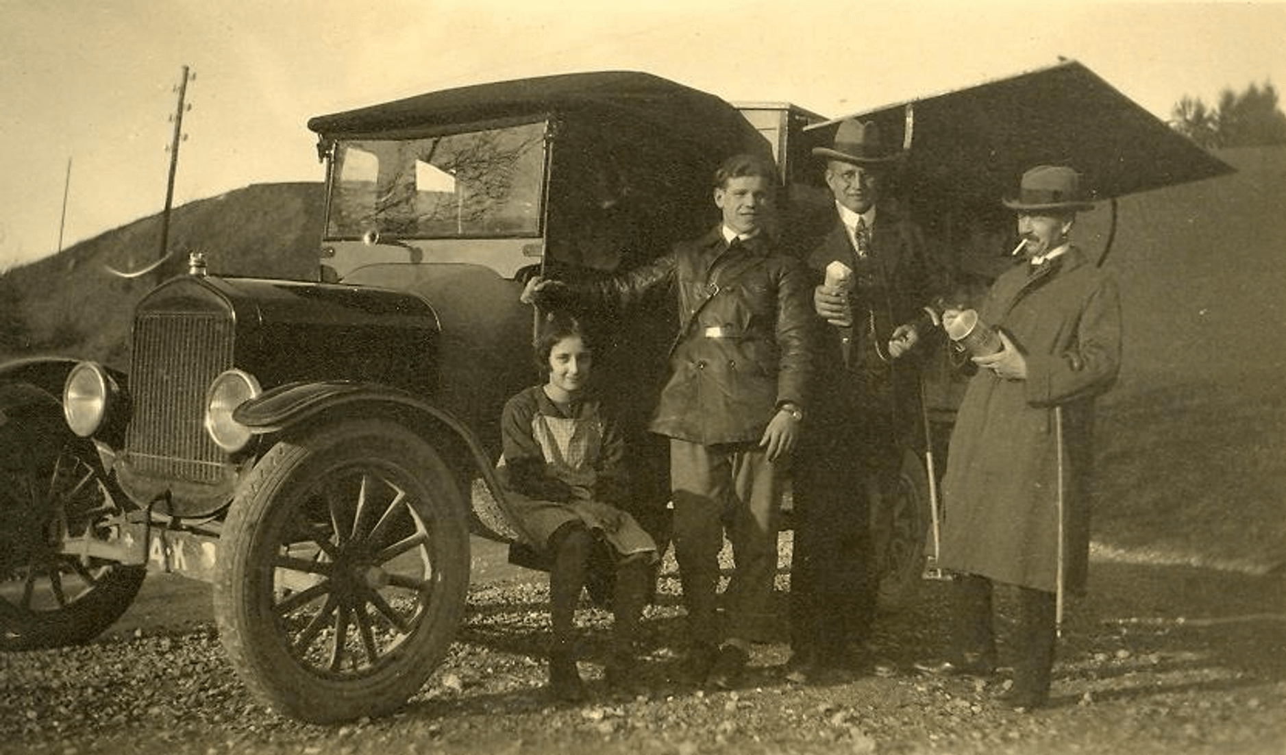 The shop assistant poses with customers in front of the Migros sales trolley (ca. 1927 - 1935).