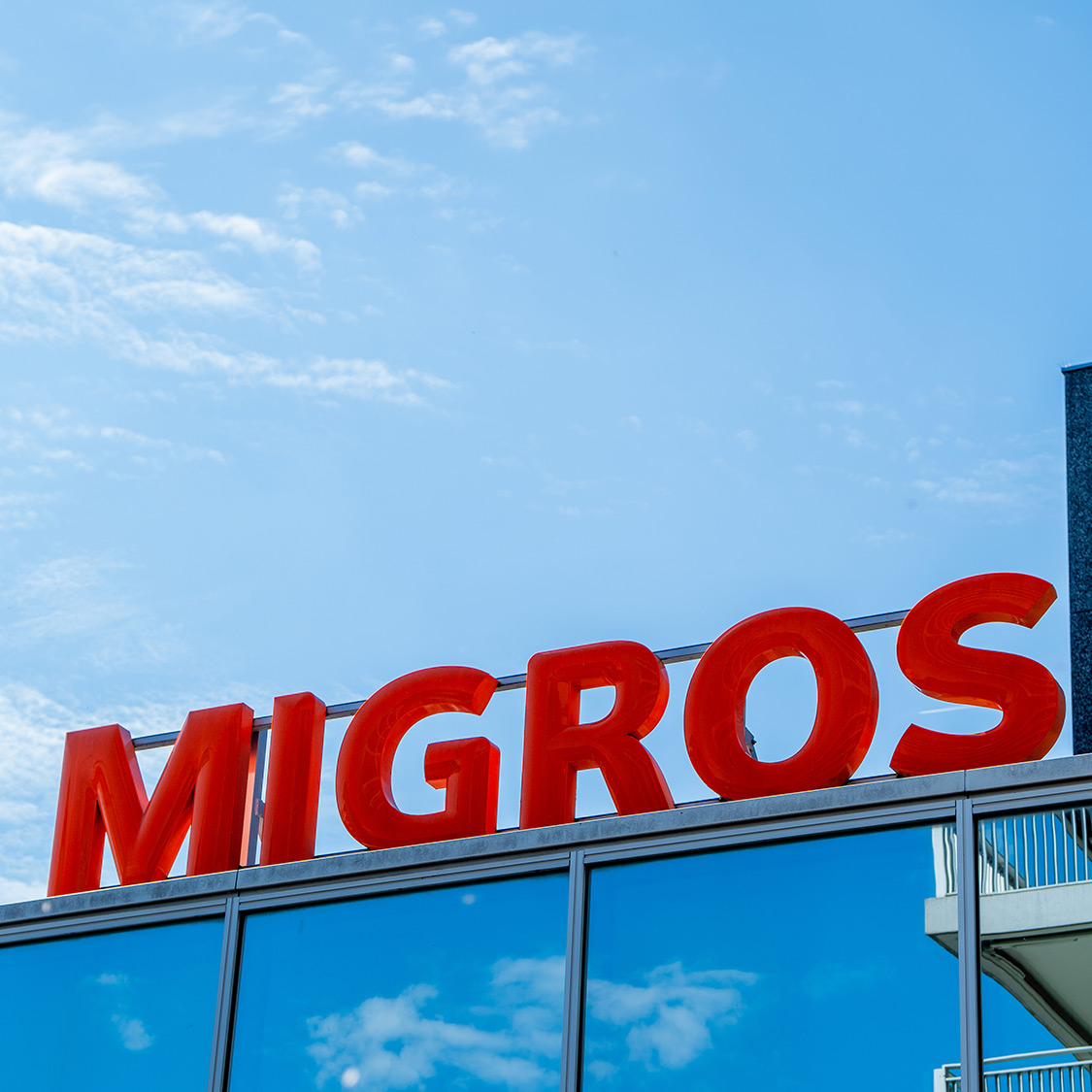 Enseigne Migros sur le toit d'un bâtiment
