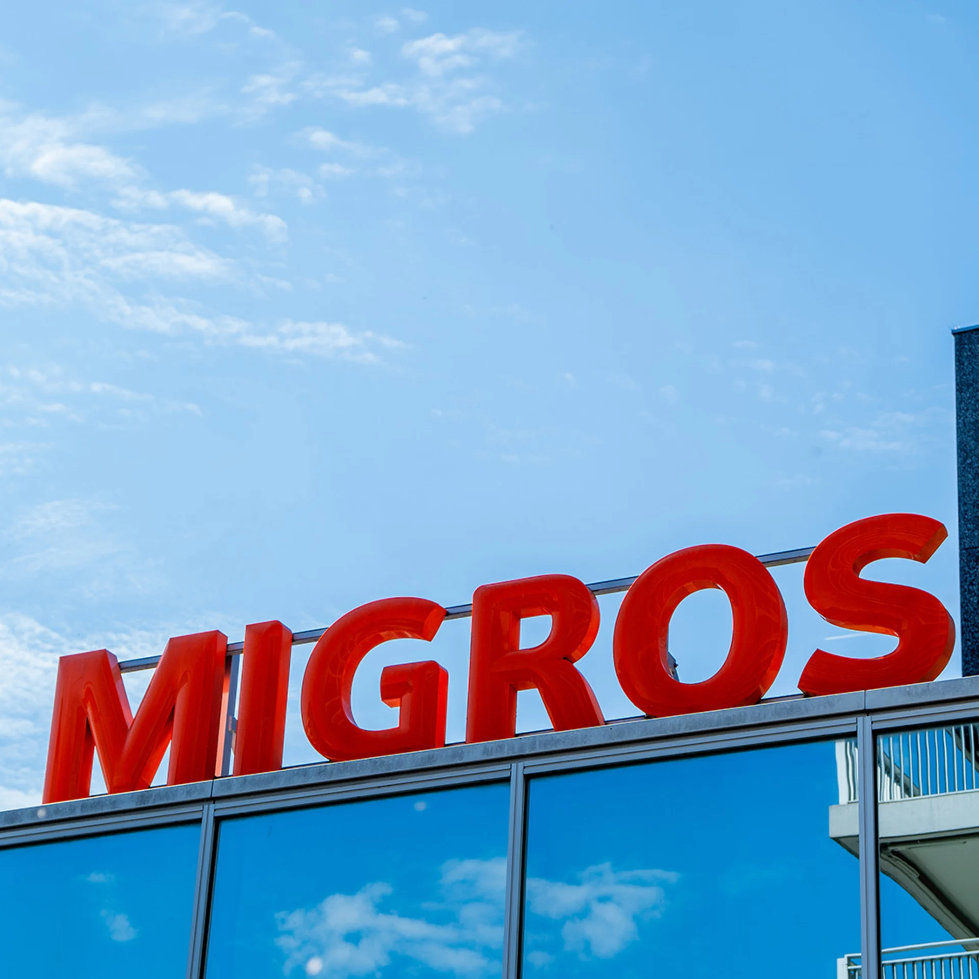 Enseigne Migros sur le toit d'un bâtiment