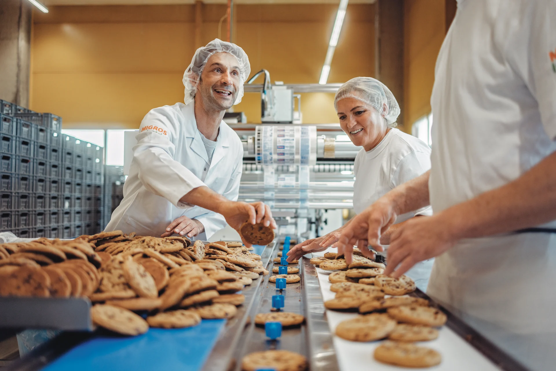 Migros employees check cookies on the assembly line
