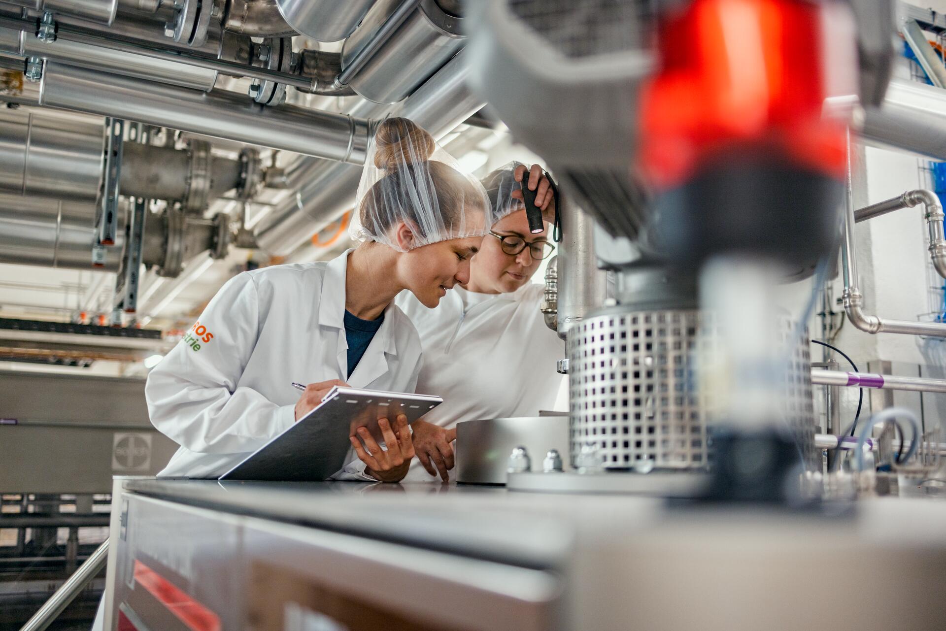 Due dipendenti al lavoro su una macchina