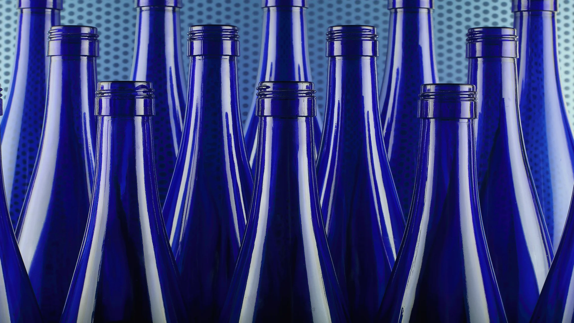 Des bouteilles en verre bleu sont serrées les unes contre les autres