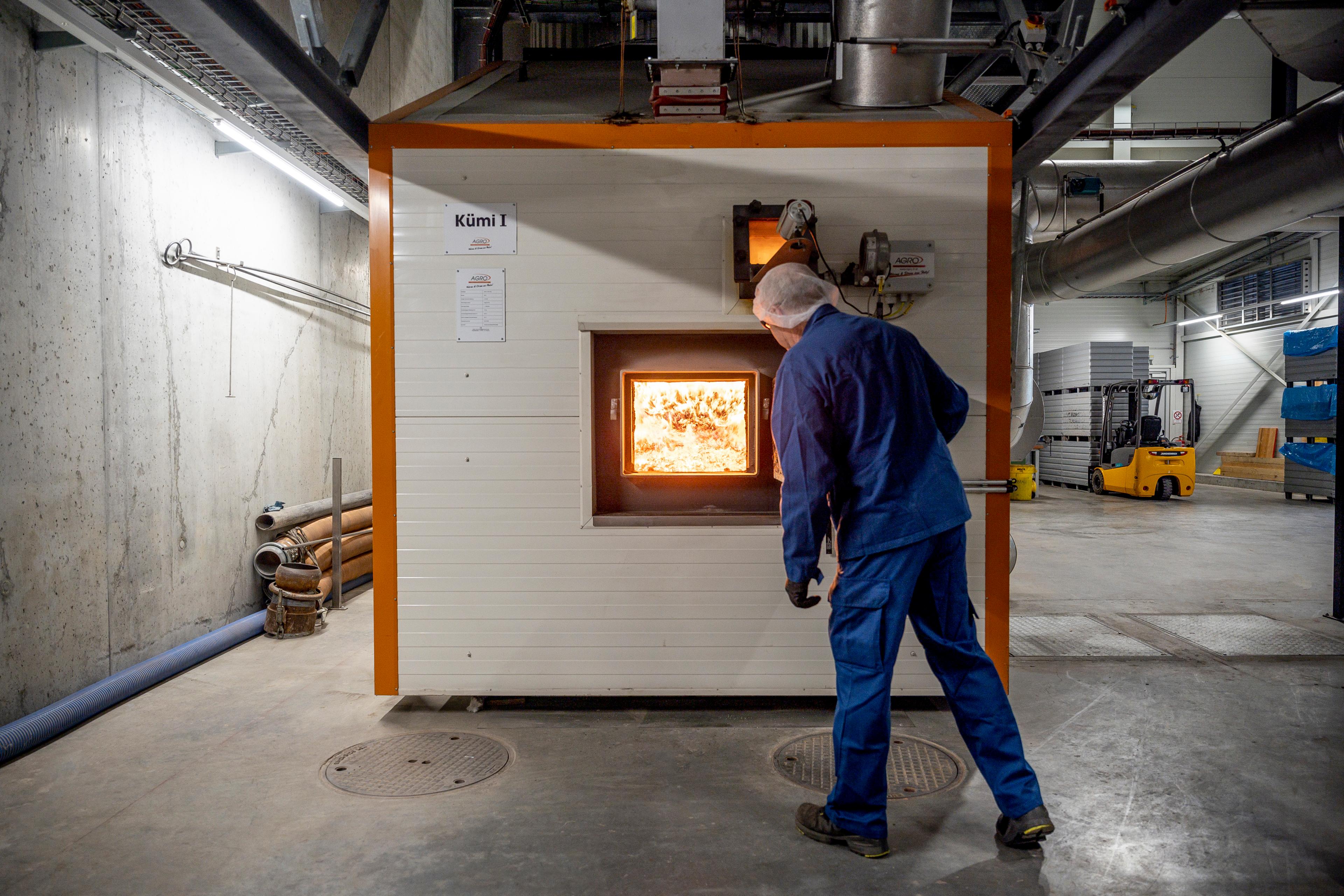 Ein Mitarbeiter in einer Halle vor einem Brennofen.