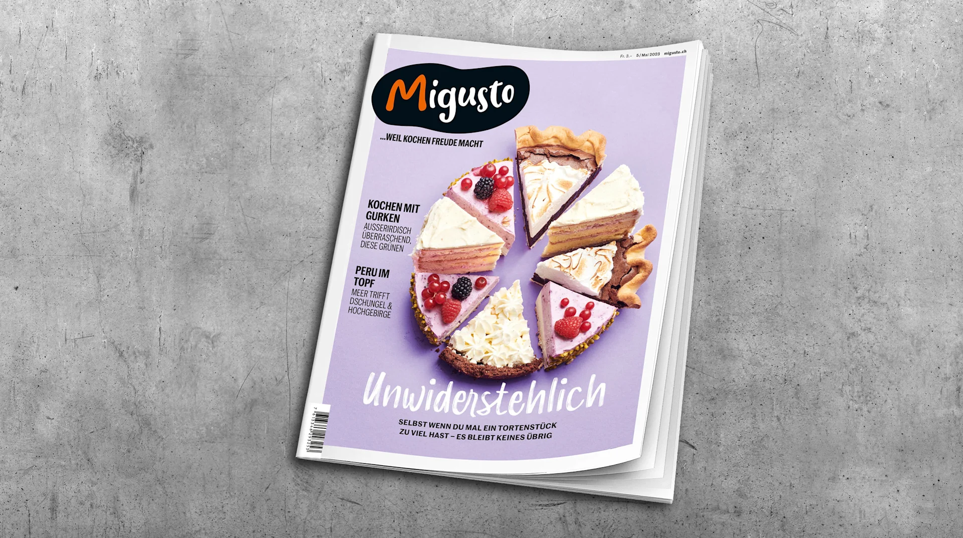 Eine Ausgabe vom Migusto Kochmagazin auf einem grauen Tisch.