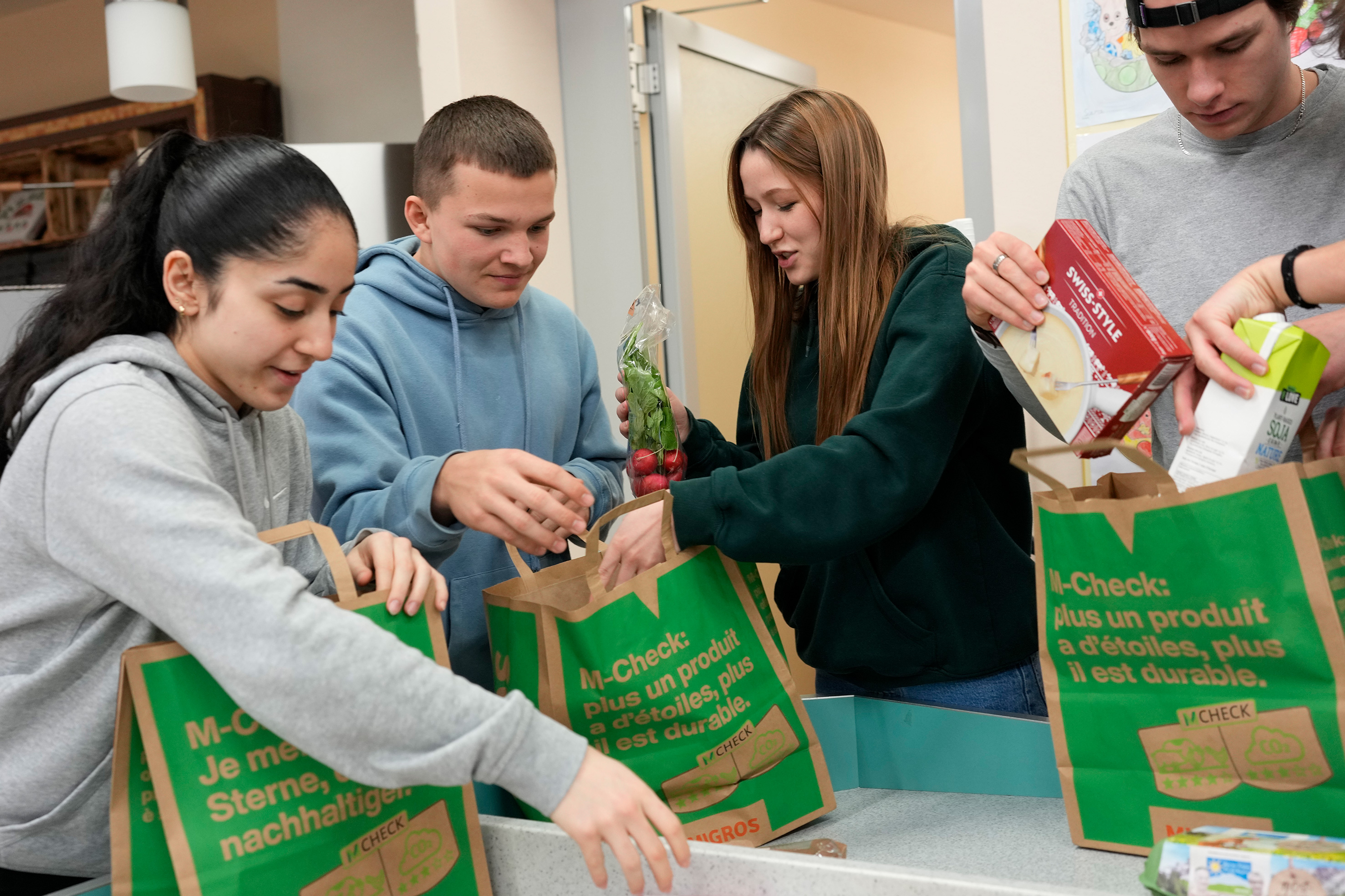 Students putting their shopping into bags.