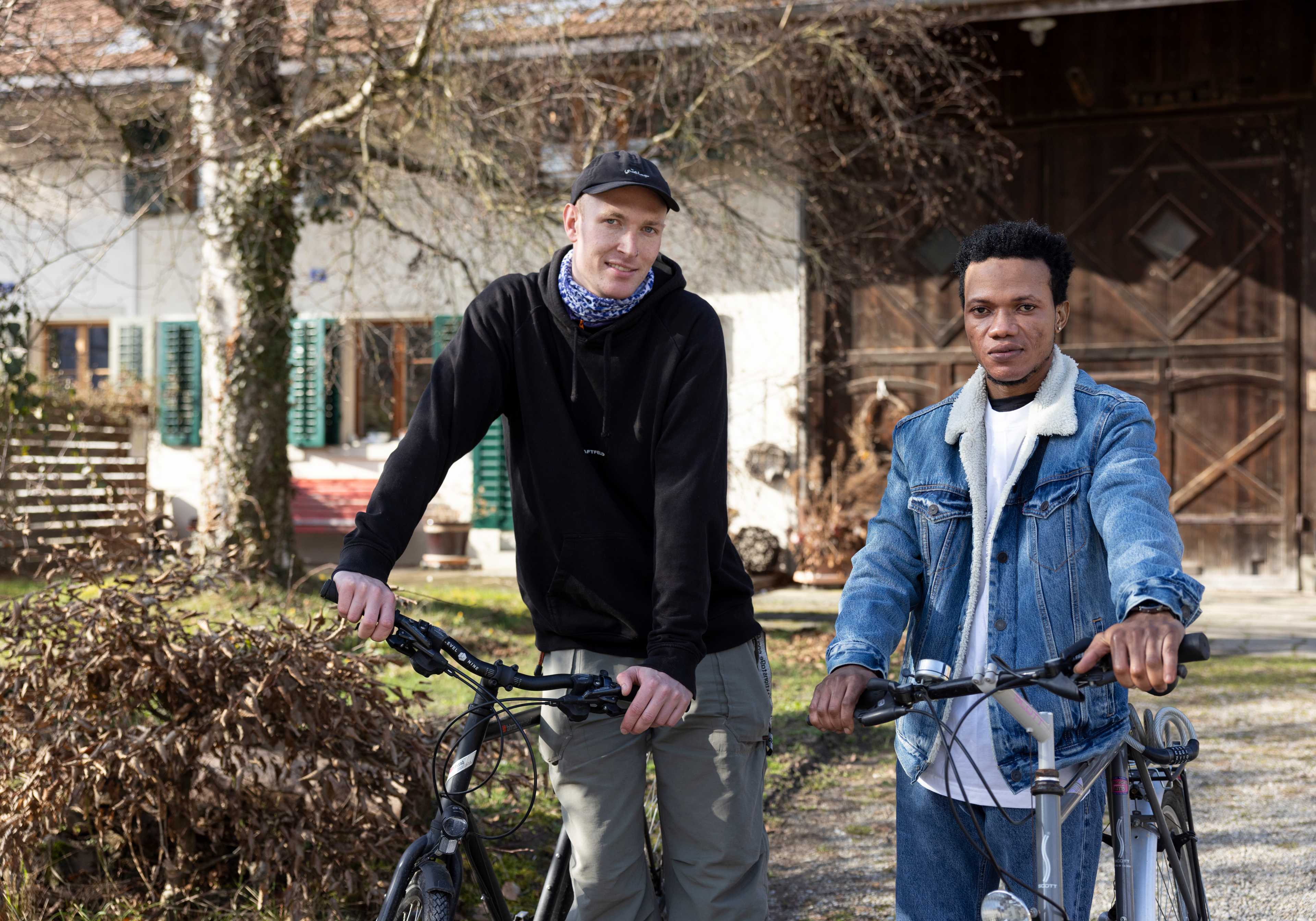 Hannes Neuhaus und Santos Morray stehen draussen mit Fahrrädern.