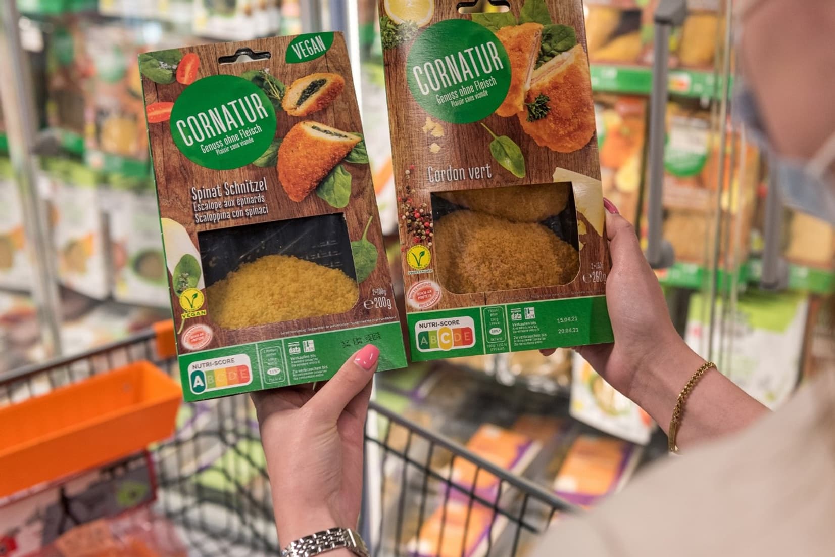 Person hält zwei Produkte von Cornatur in den Händen, darauf der Nutri-Score