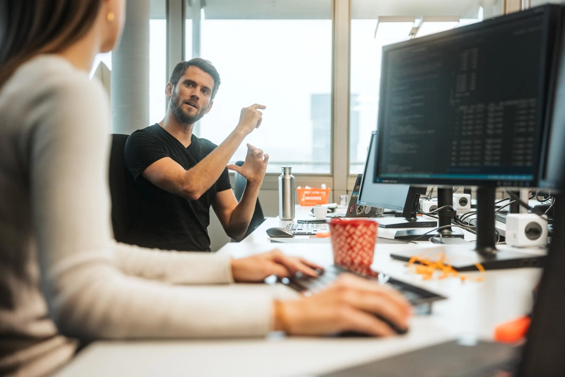 Two employees in the office discussing with each other
