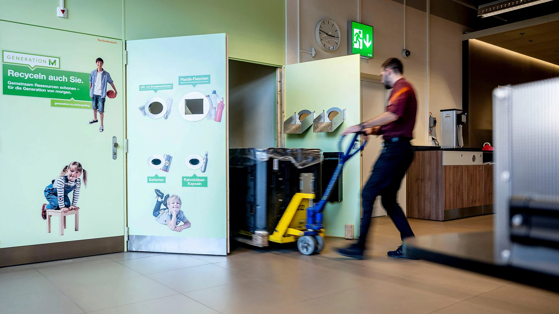 Un collaborateur Migros place un conteneur dans un point de collecte.