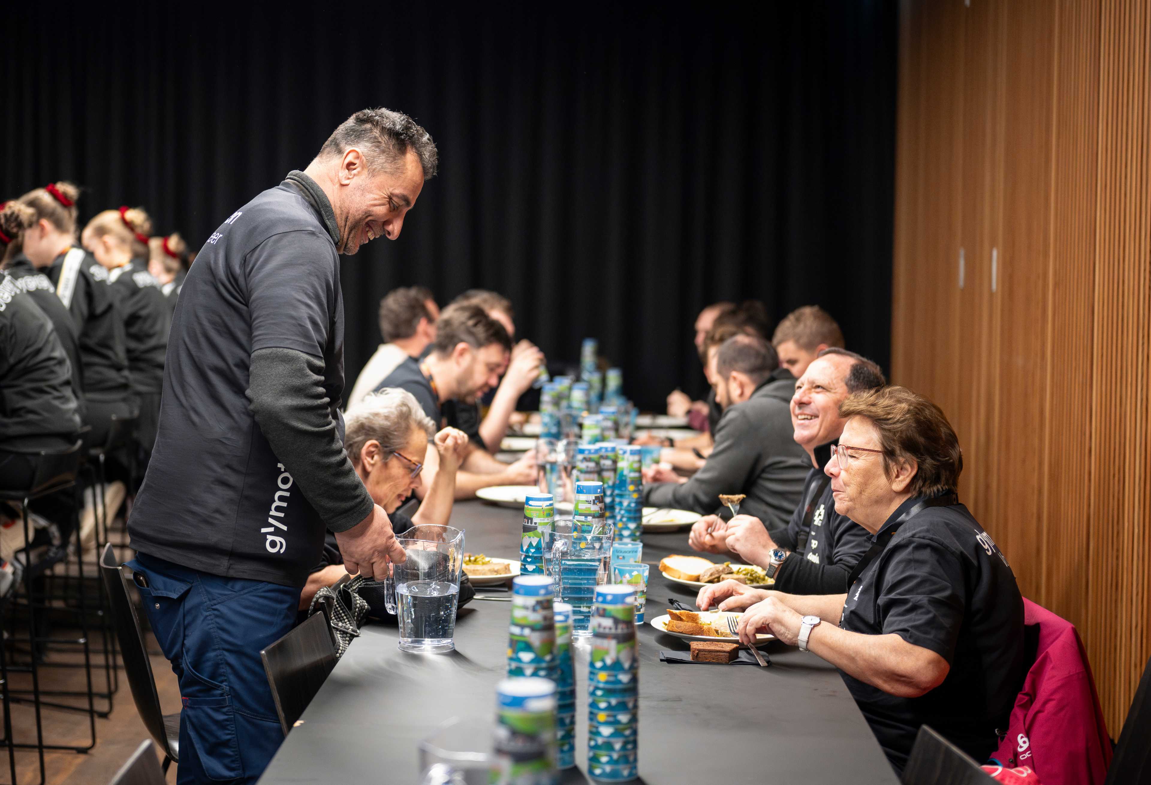 Sam Rabah remplit des verres vides à une table