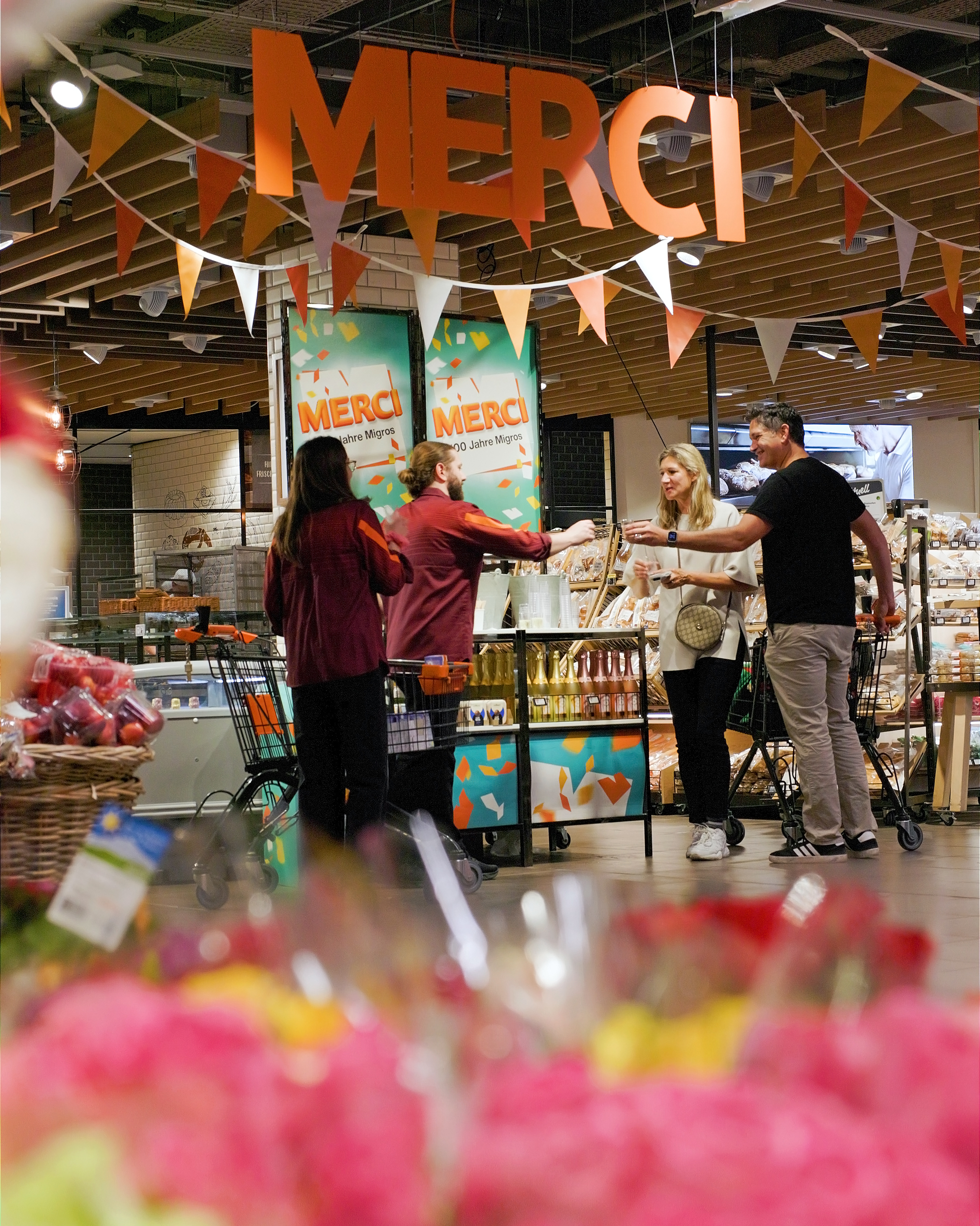 Fête d’anniversaire dans les magasins: le personnel accueille les clientes et les clients avec des boissons et une décoration colorée.