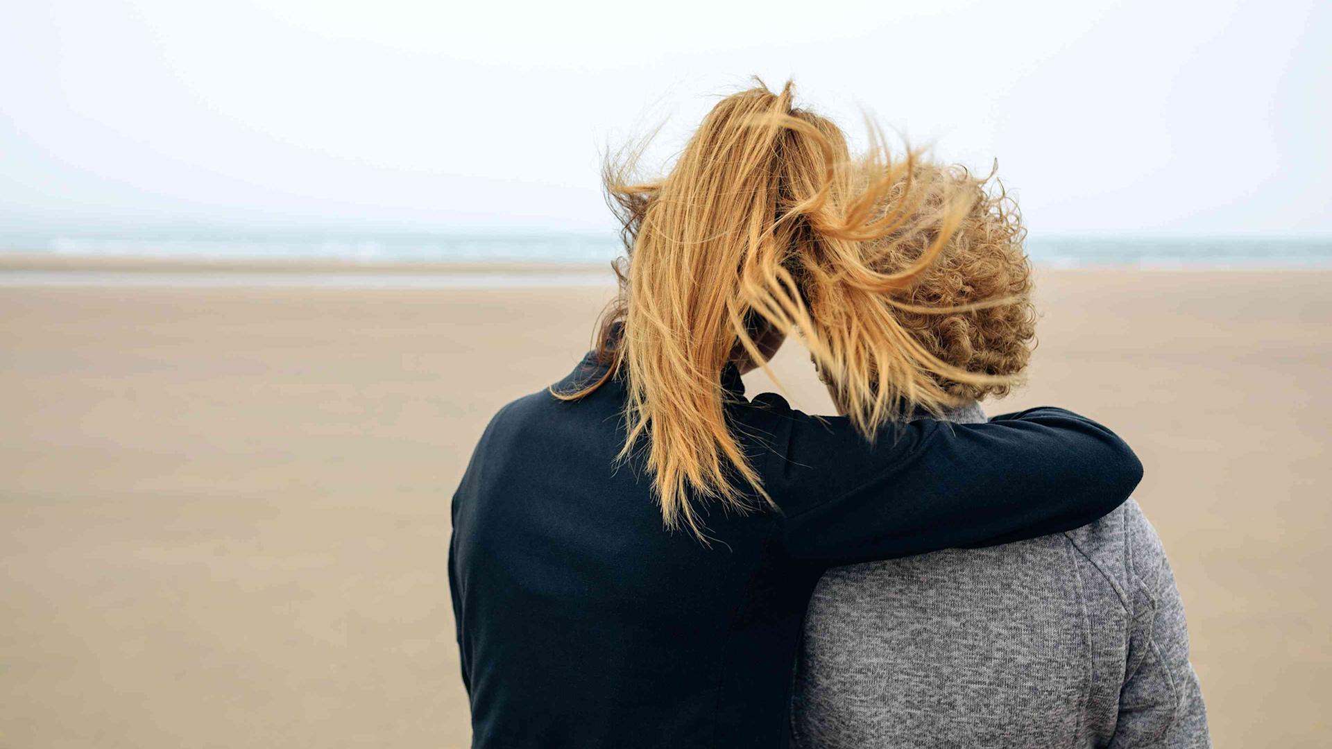 Back view of a younger and an older woman at the beach