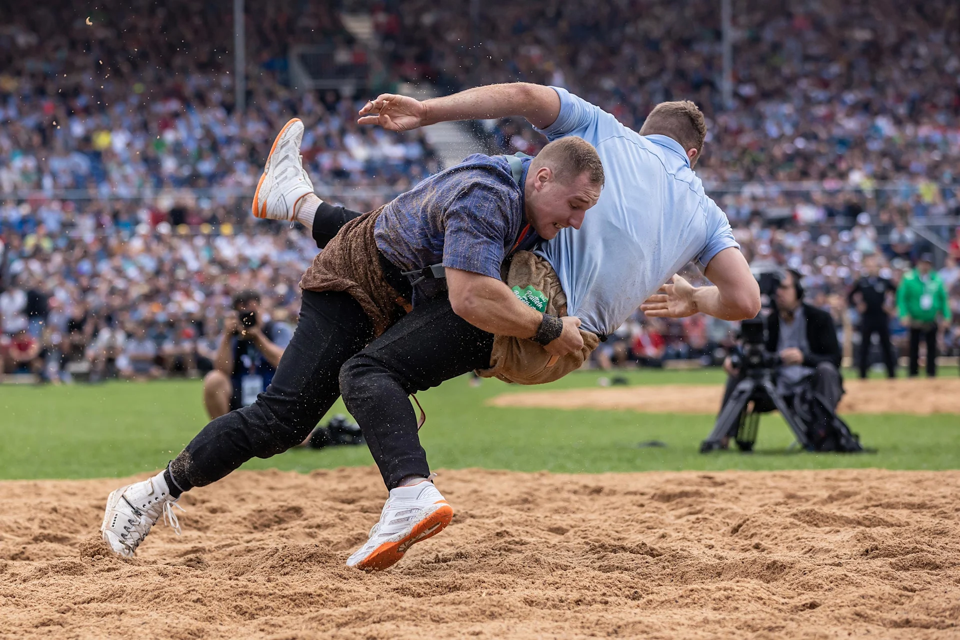 Two men trying to throw each other onto the ground in one fell swoop.