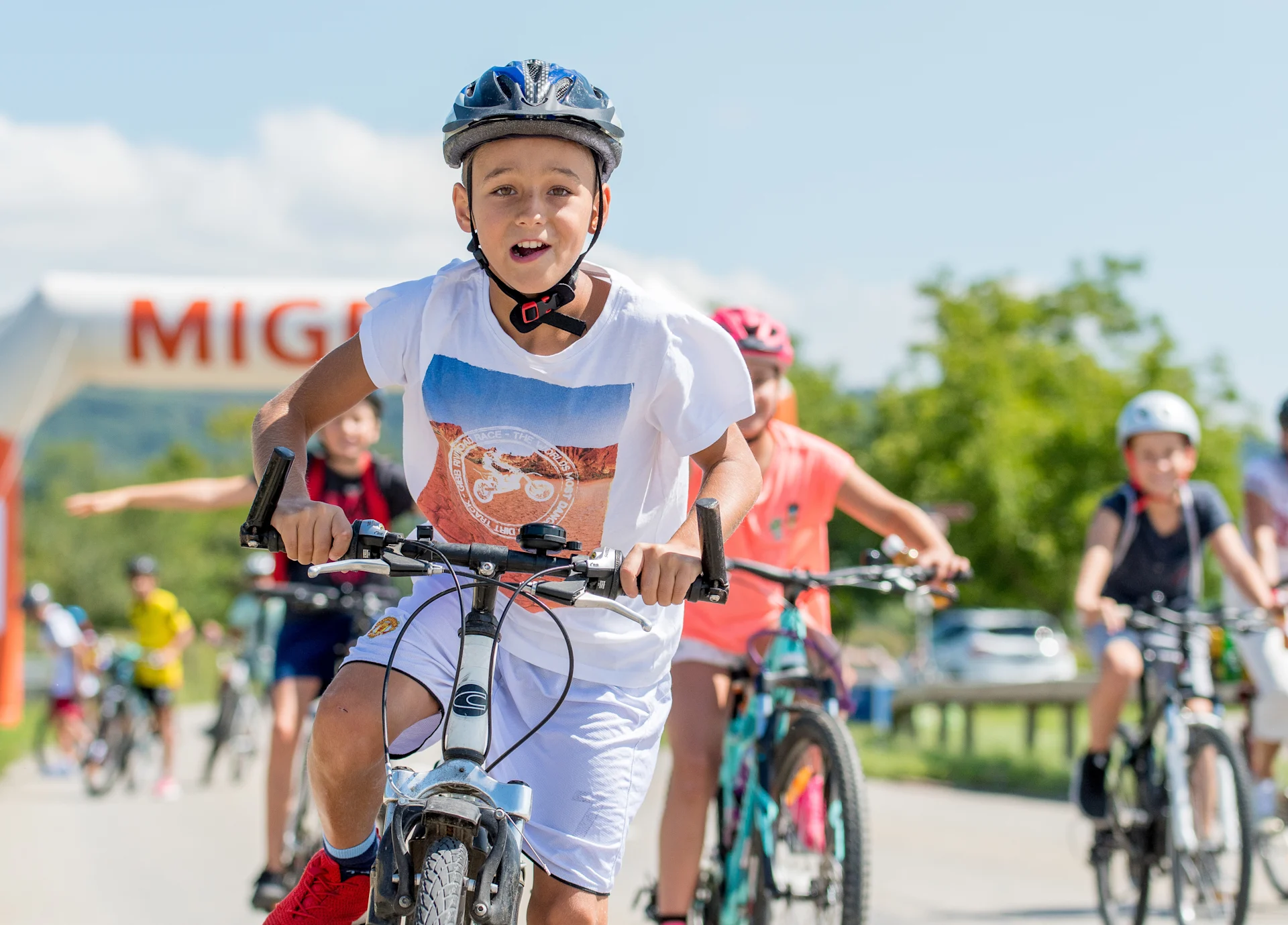 Dei bambini vanno in bici per strada.