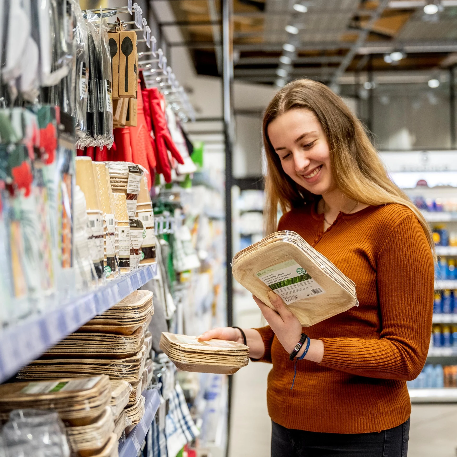 Eine Frau hält ein Pack Mehrwegteller in der Hand