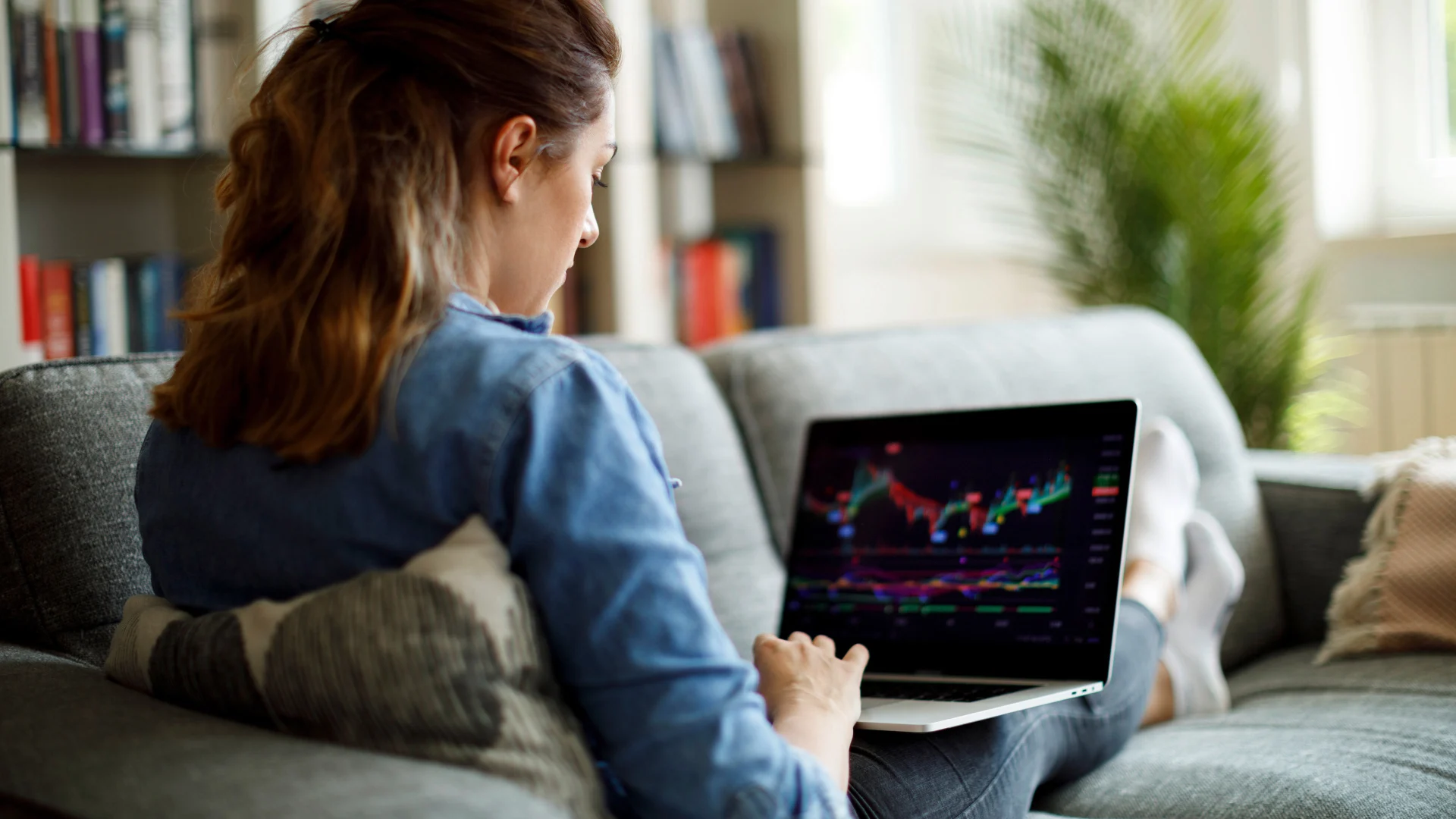 A young woman looking at a share price history on her laptop.