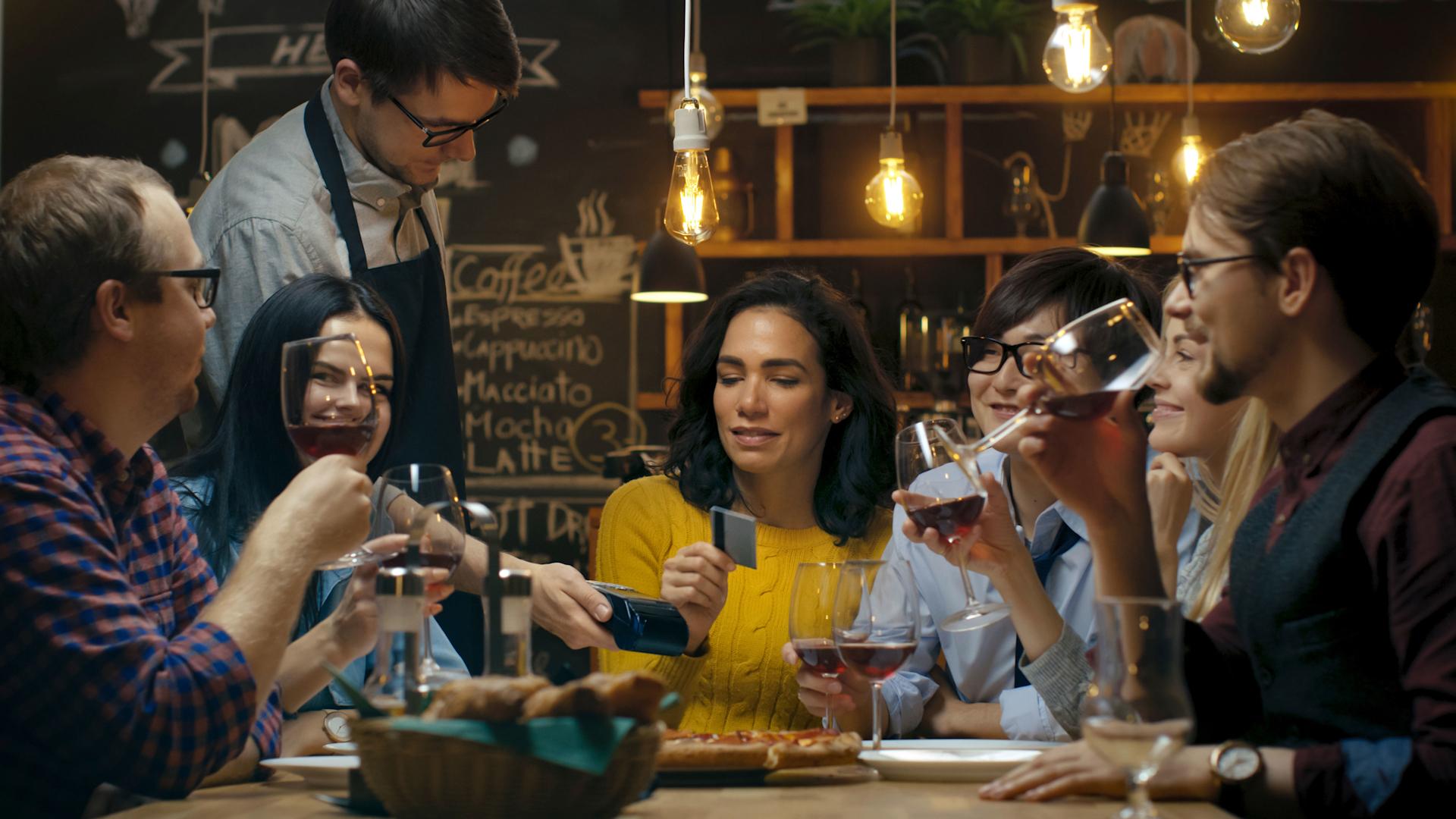 A woman pays the bill with a card in a restaurant