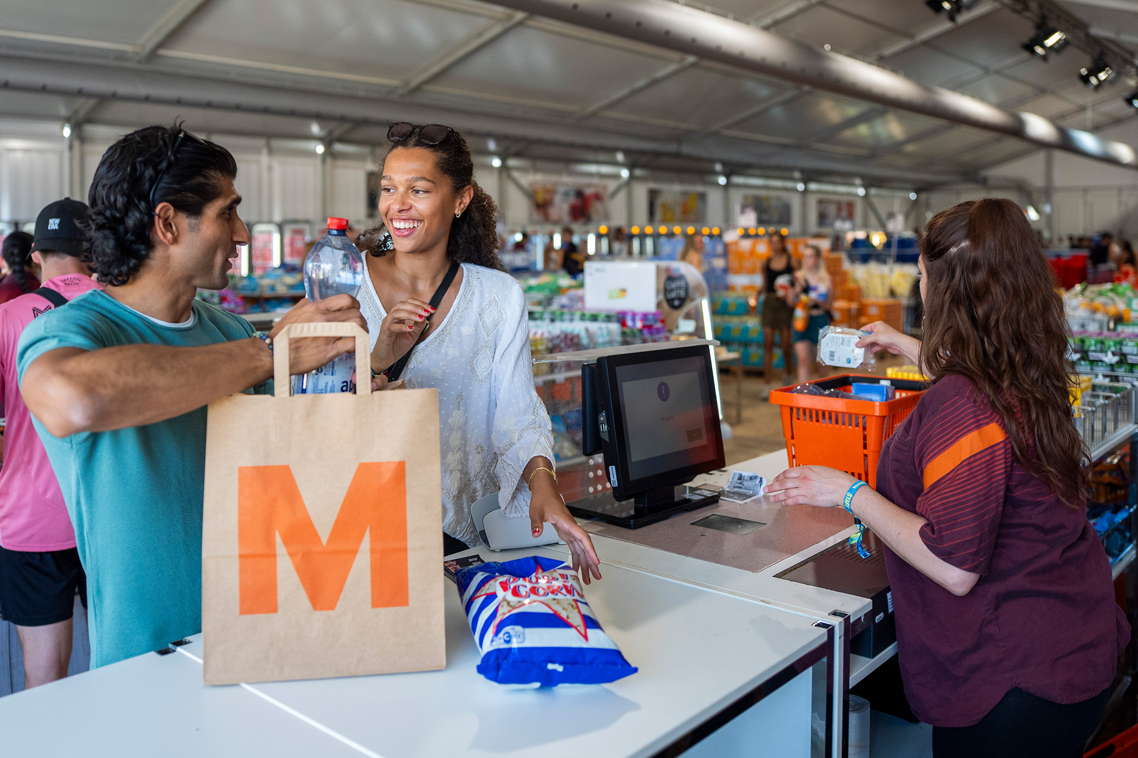 Young people shop at the Migros store on the festival grounds.