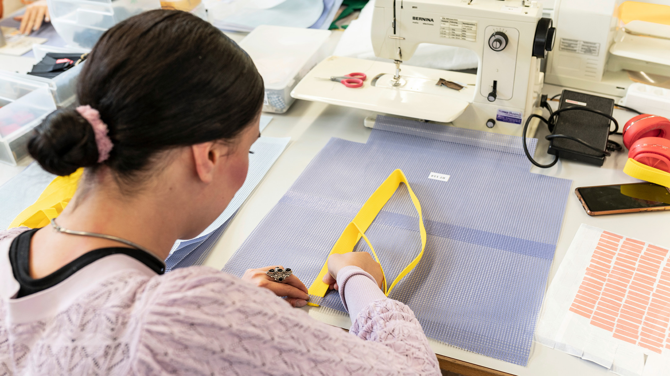 Mitarbeitende von Drahtzug stellen die Eistee-Taschen her.