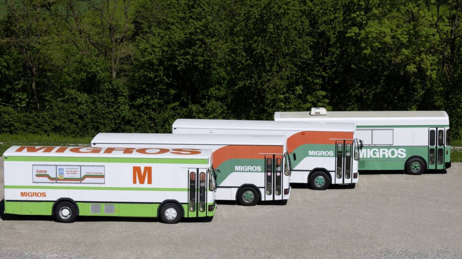 Vier parkierte Migros-Busse