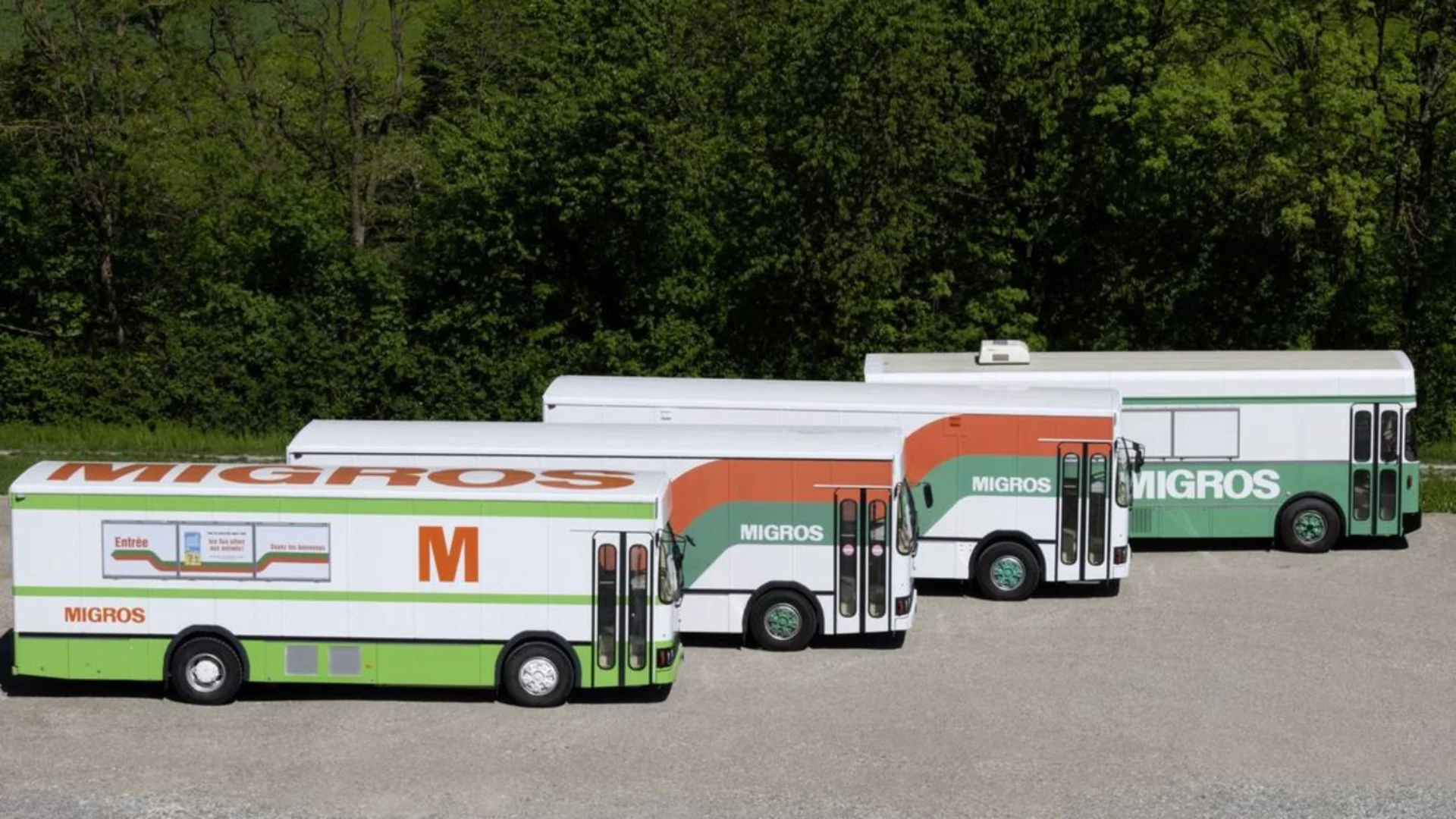 Vier parkierte Migros-Busse