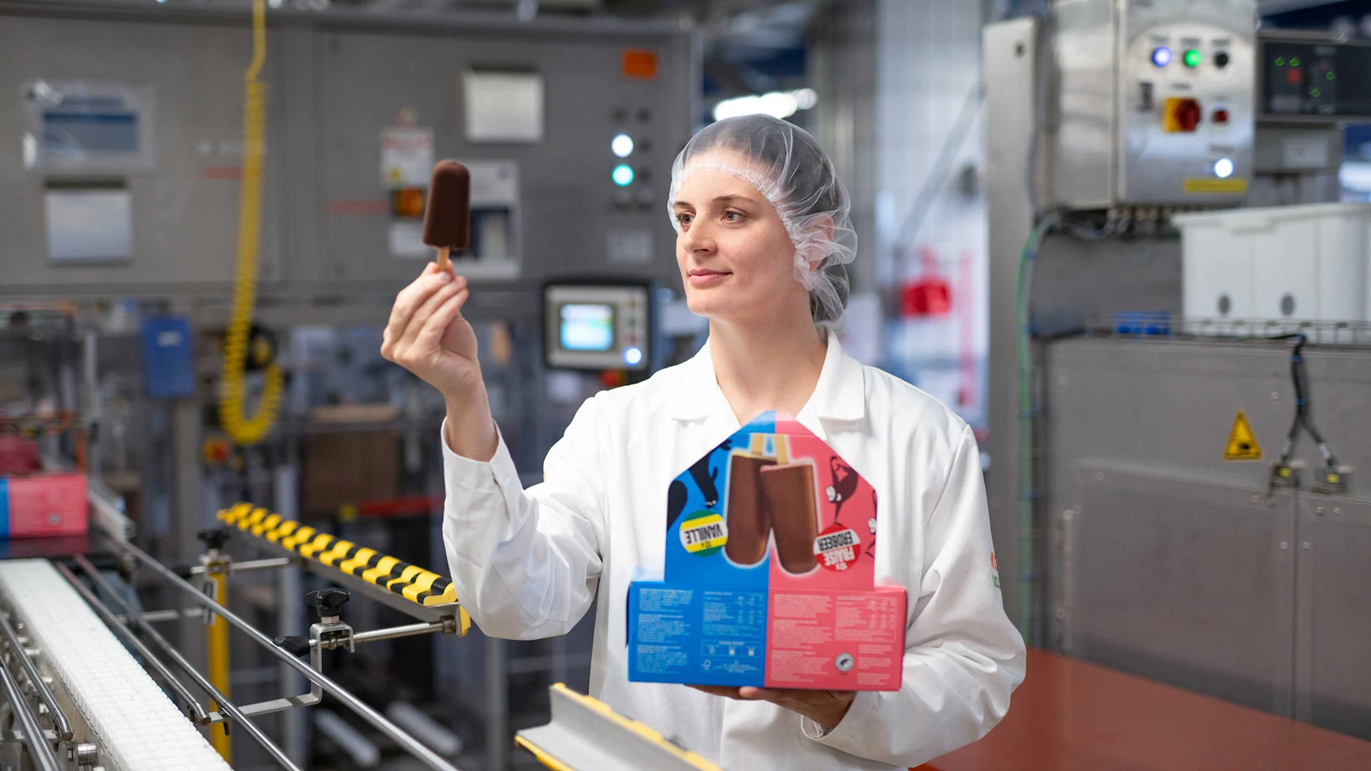 Un dipendente controlla l'aspetto di un gelato a stecco sulla linea di assemblaggio