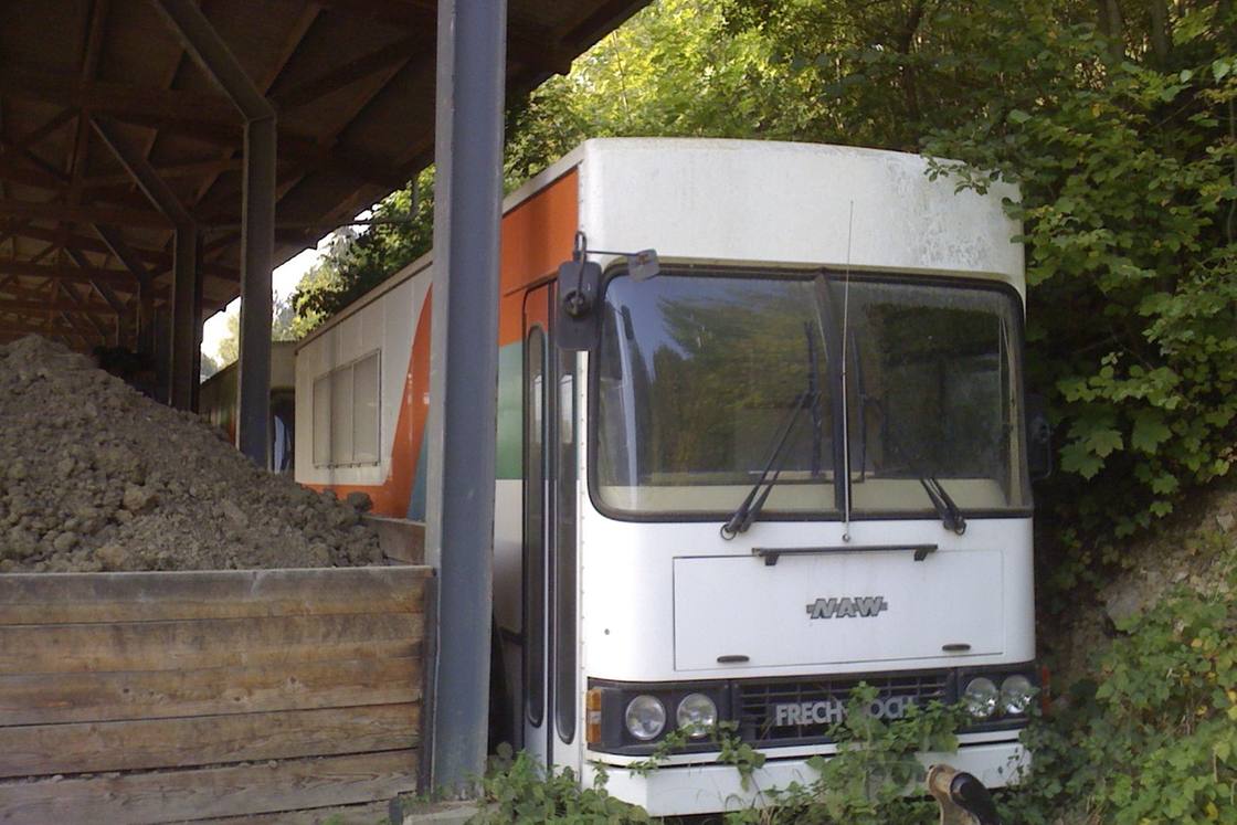 Ein Migros-Bus steht draussen unter einem Dach