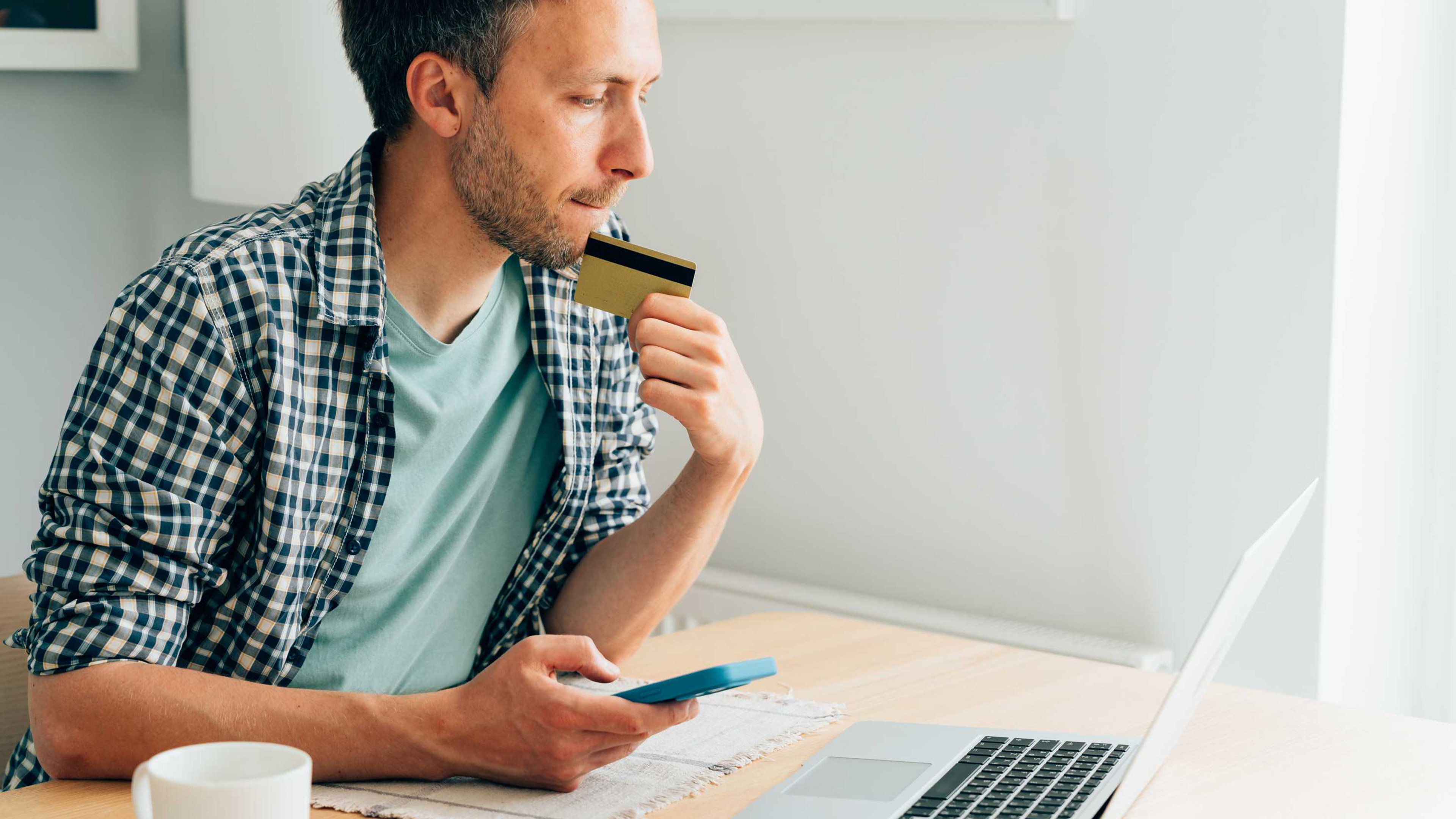 Un uomo inserisce i dati di pagamento su un computer portatile