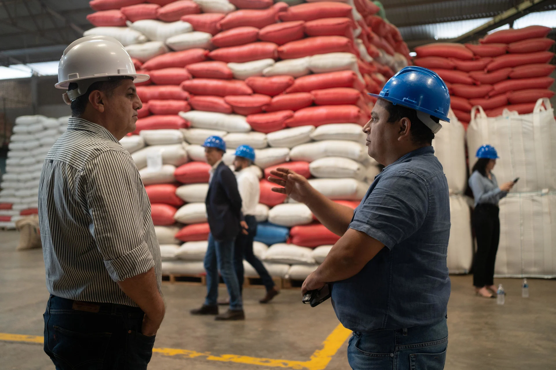  Two workers stand in a warehouse and discuss with each other