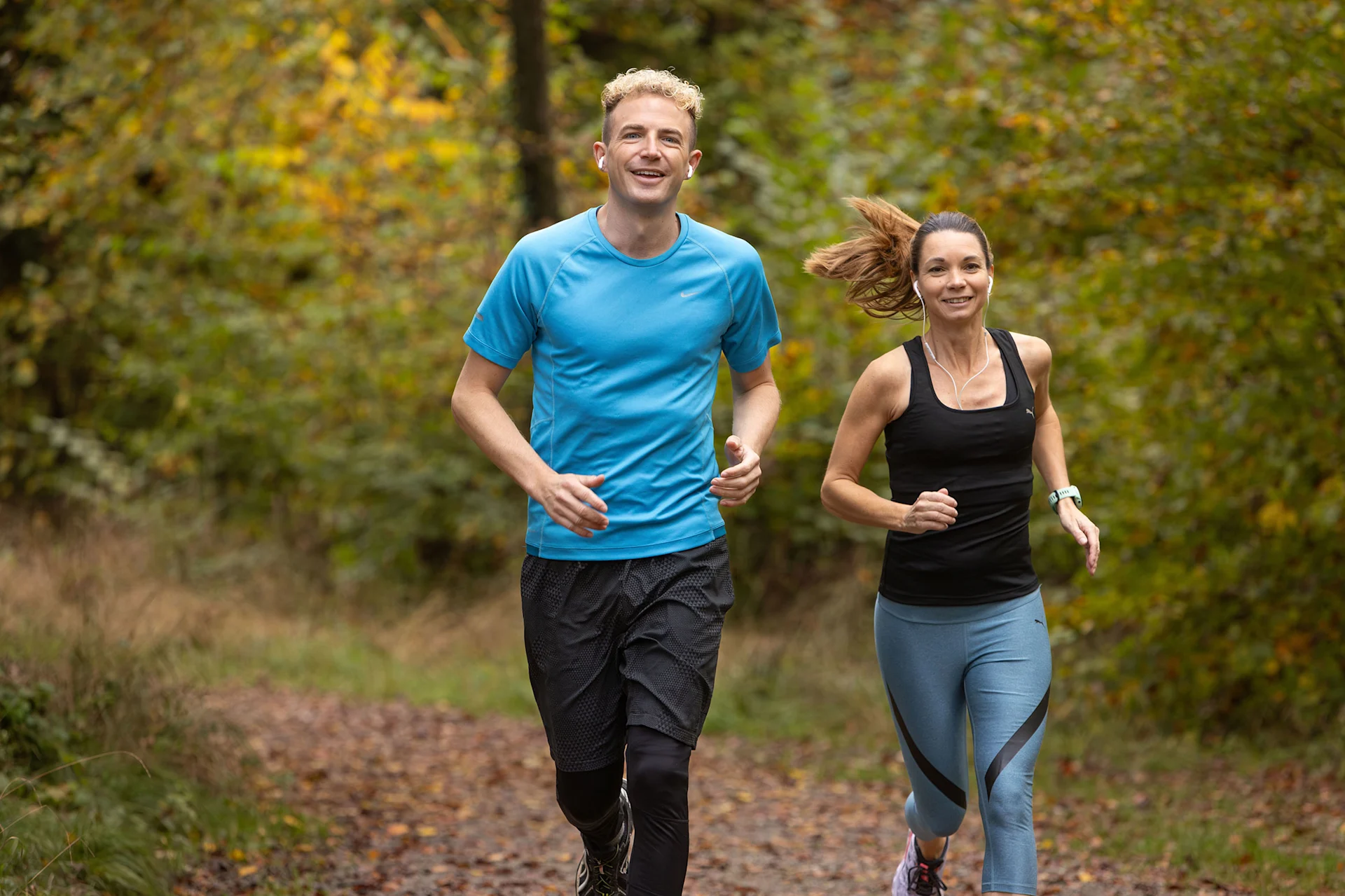Eine Frau joggt mit Michael Elsener durch den Wald