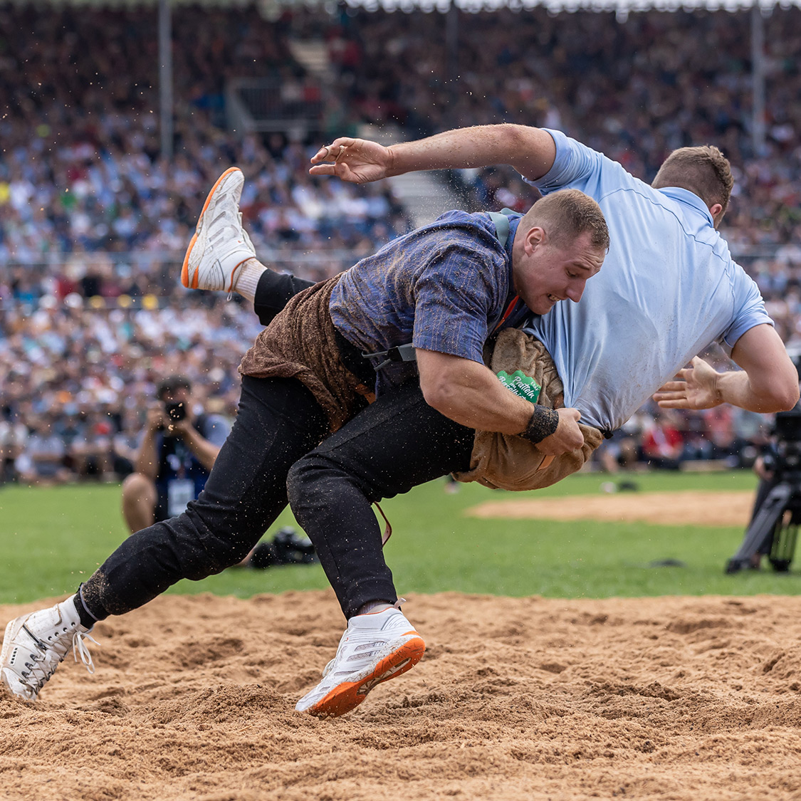 Zwei Männer versuchen, den anderen mit einem Schwung auf den Boden zu werfen. 