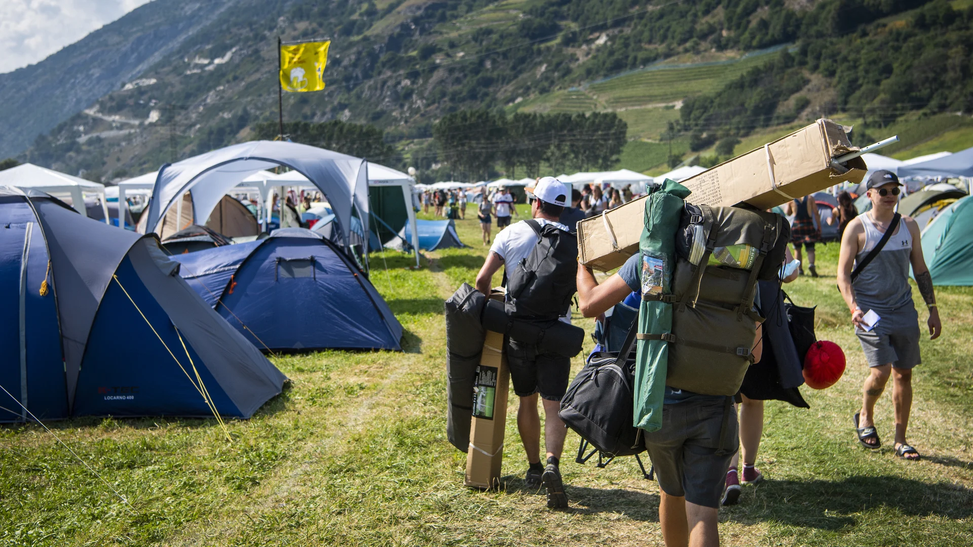Les fans du festival transportent des tentes et des bagages