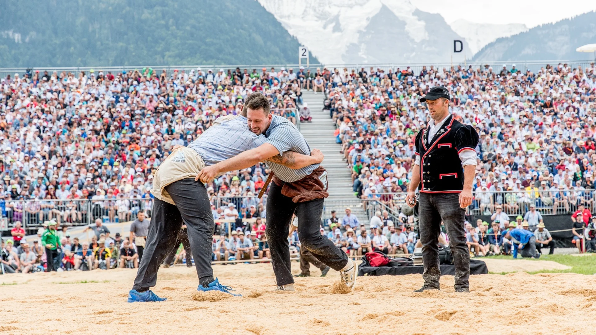 Two men trying to throw each other onto the ground in one fell swoop. 