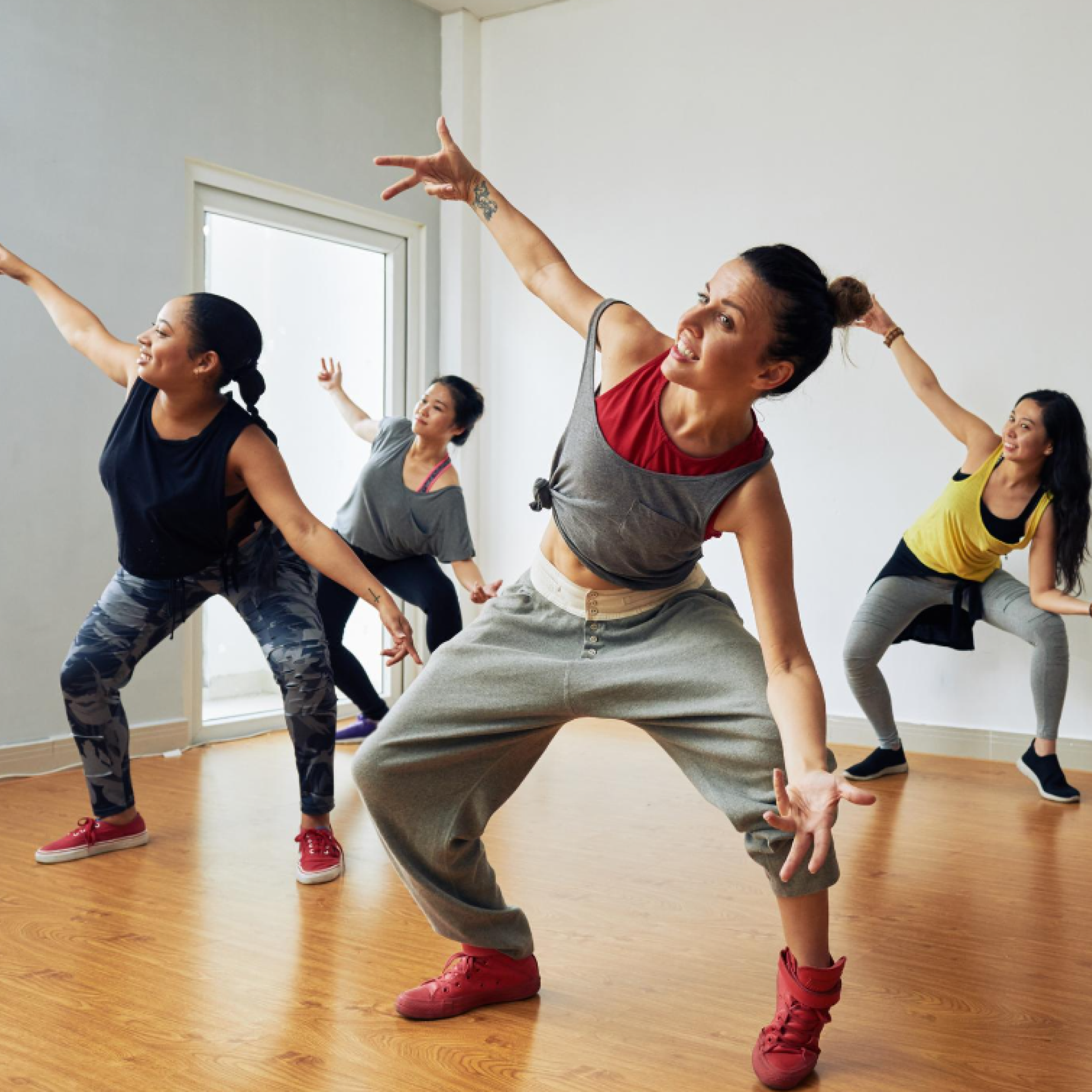 Quattro giovani donne che ballano in una lezione di fitness di gruppo