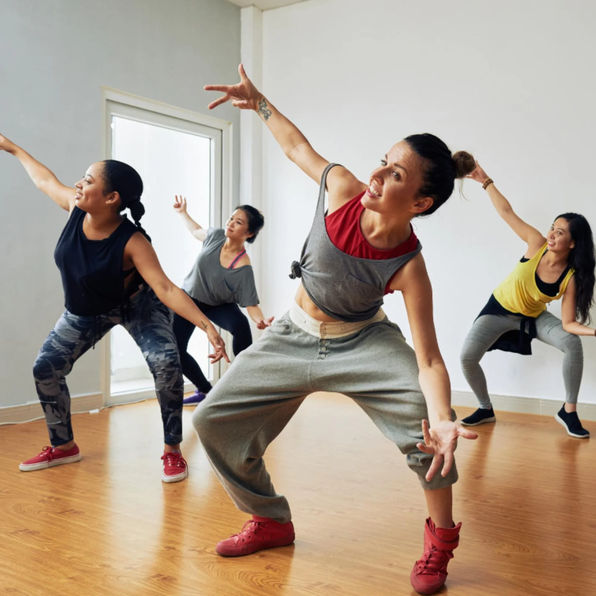 Four young women dancing in a group fitness class