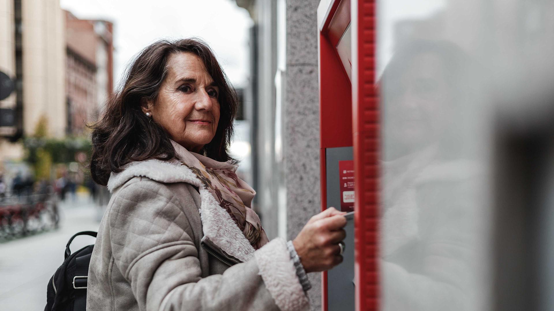 A woman withdraws money from an ATM