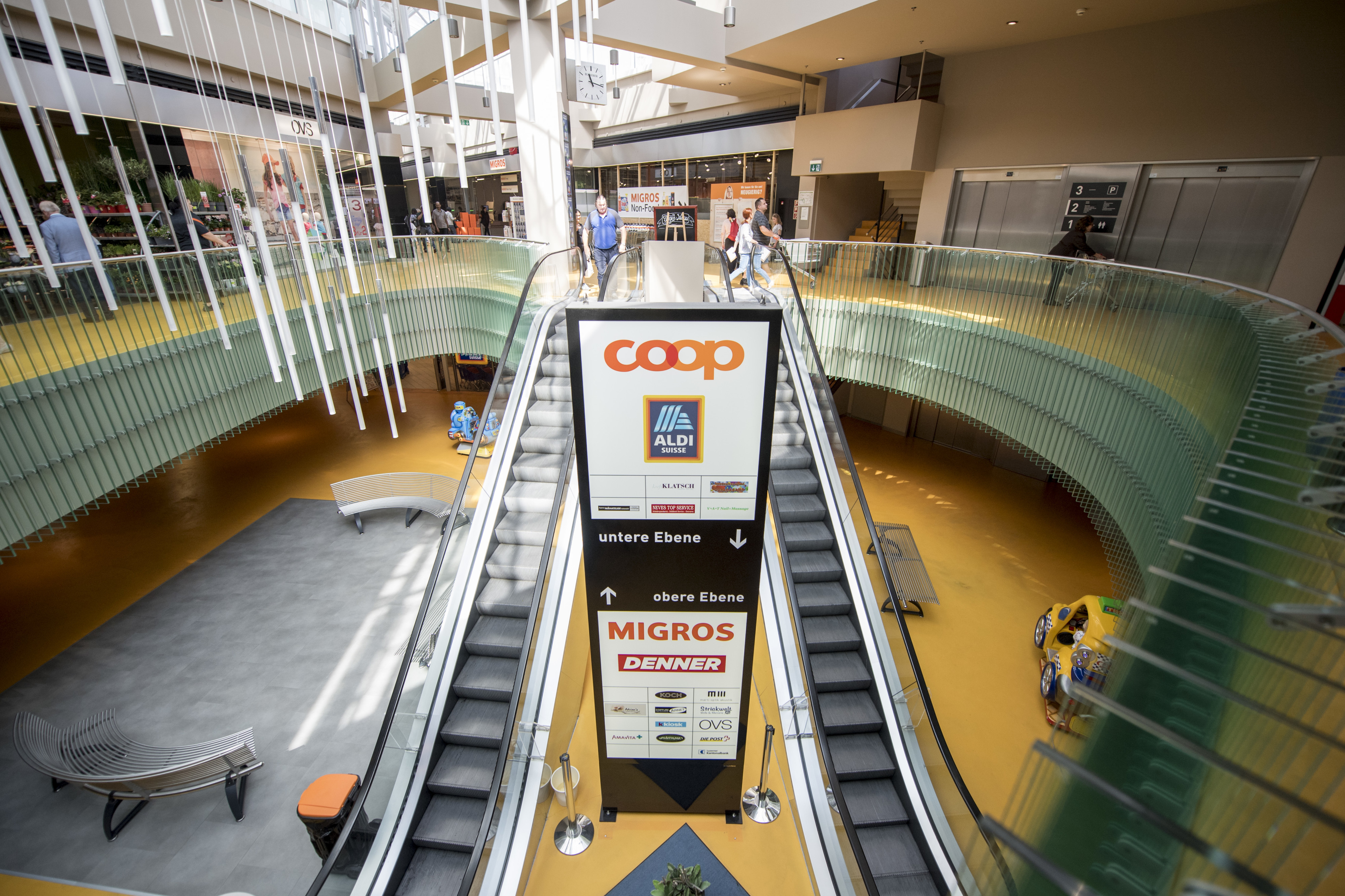 Eine Tafel mit verschiedenen Logos von Detailhandelsunternehmen in einem Einkaufszentrum.