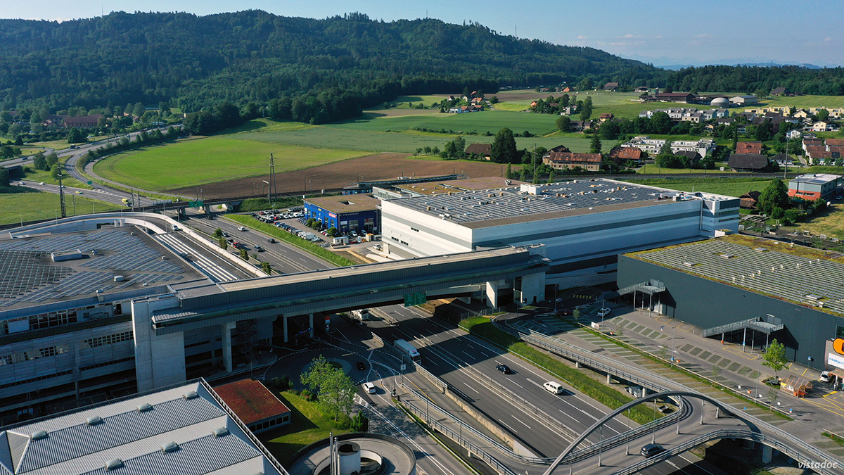 Neubau mit Fussgängerpasserelle und Autobahnbrücke